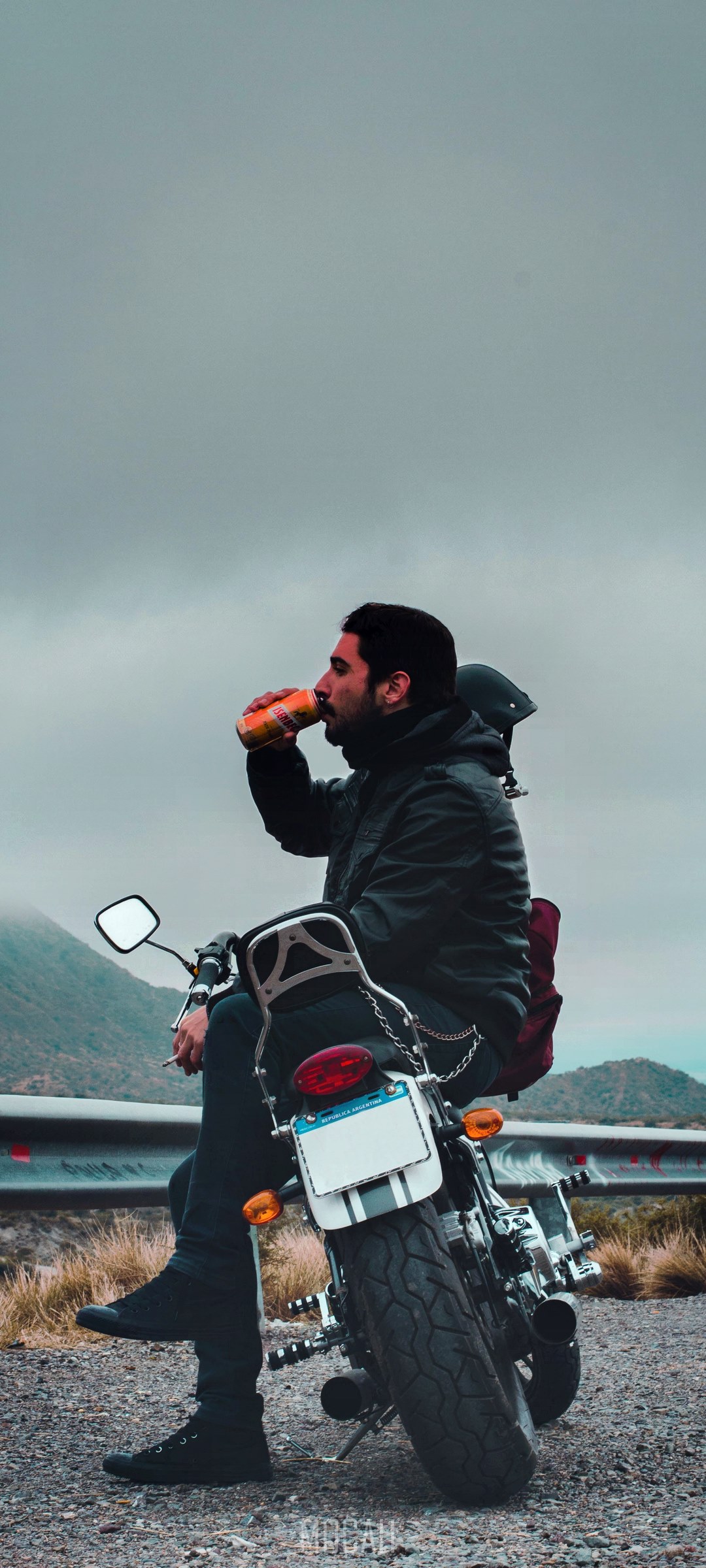 Man in jacket drinking from can on motorcycle HD Phone Wallpaper
