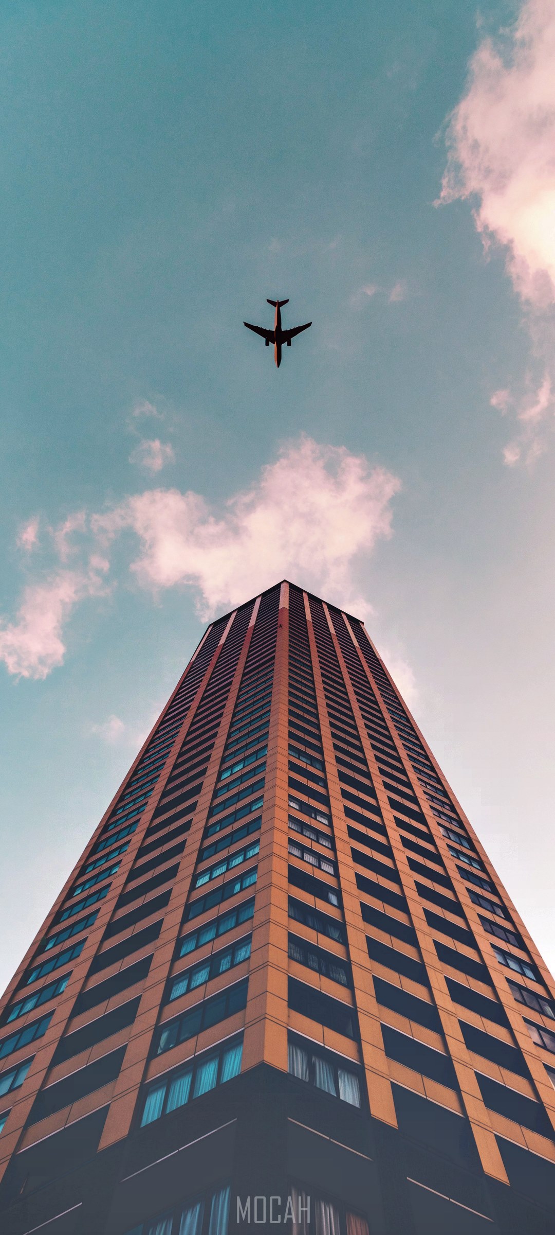 Airplane flying over a skyscraper HD Phone Wallpaper