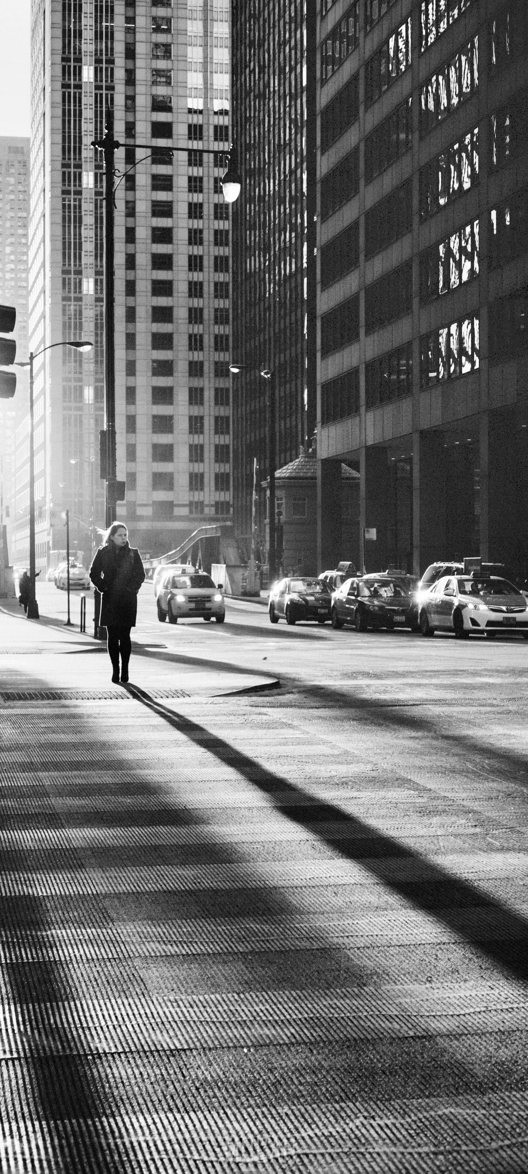 Woman walking on city street with skyscrapers and cars HD Phone Wallpaper