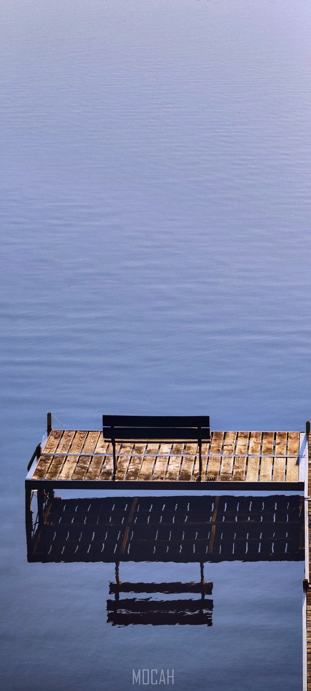 Empty wooden dock with a bench over calm water HD Phone Wallpaper