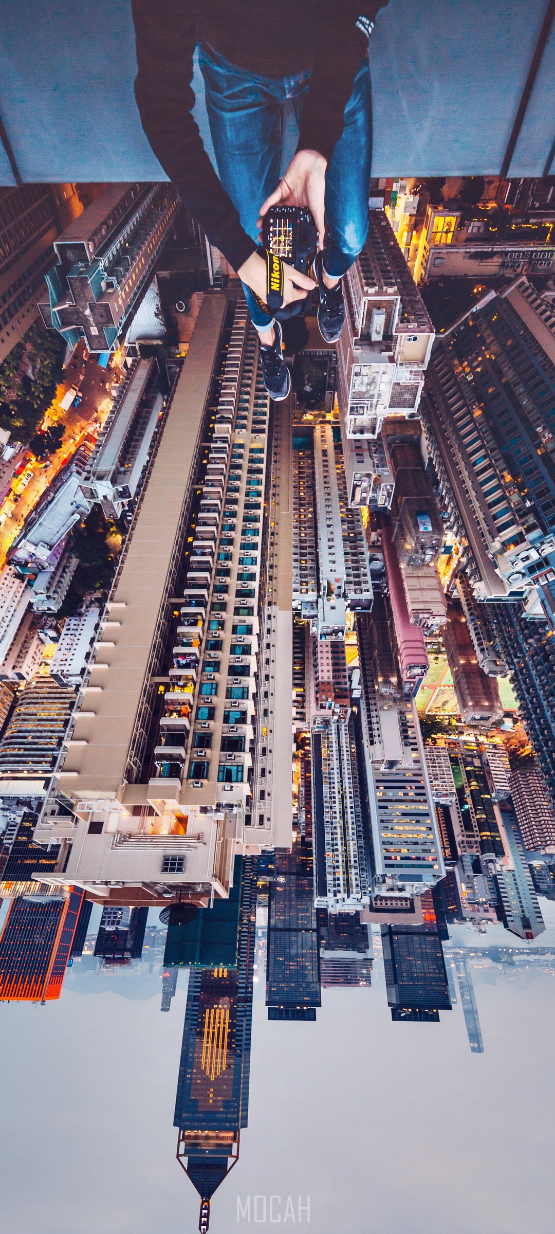 Person holding Nikon camera on skyscraper overlooking city HD Phone Wallpaper