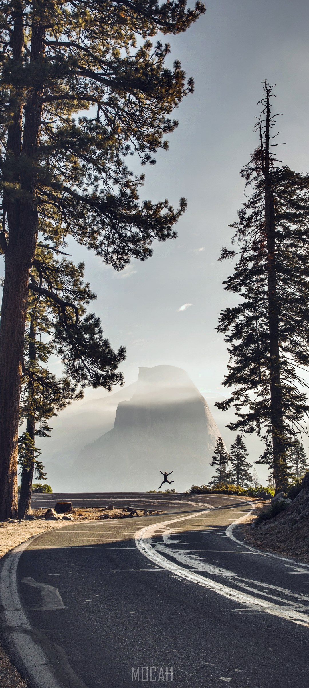 Person jumping on road with Half Dome in background HD Phone Wallpaper