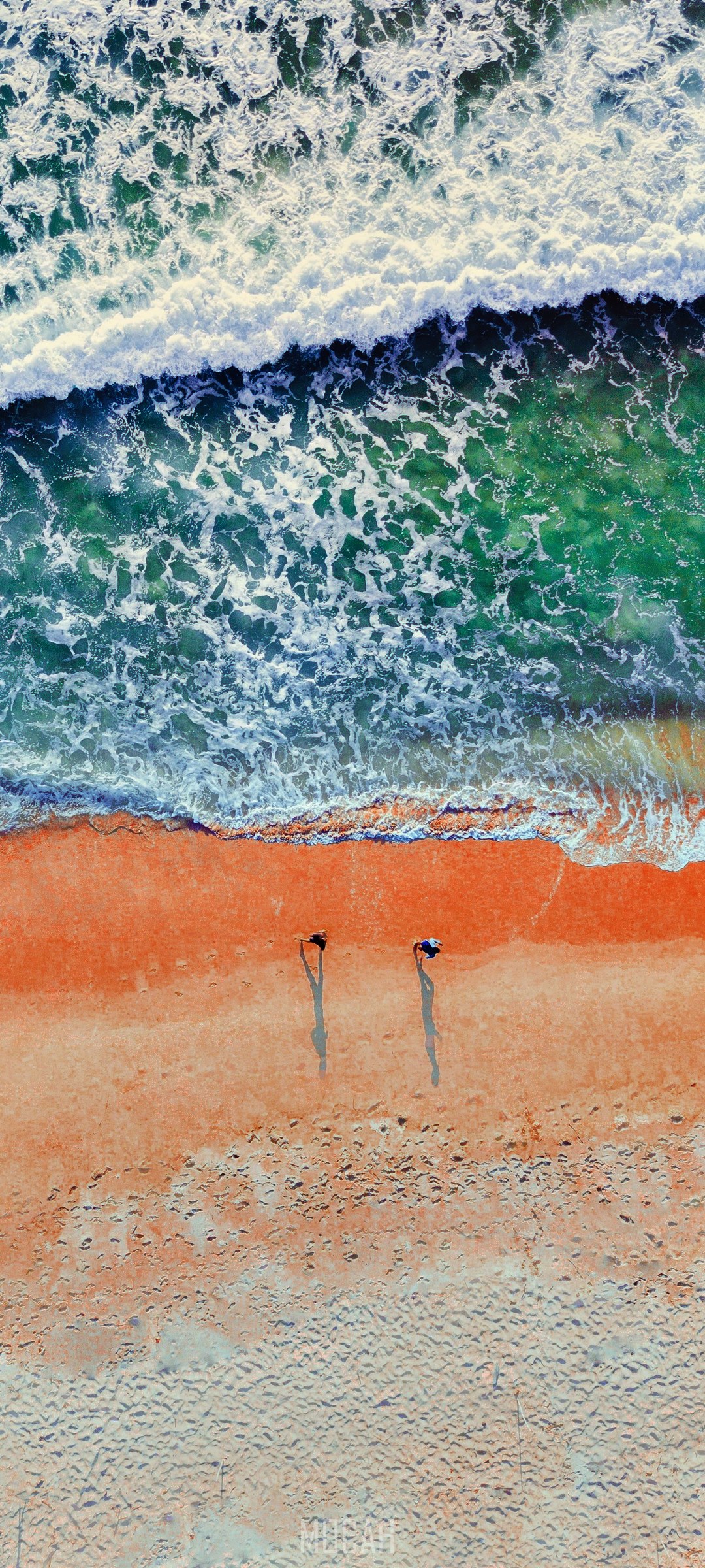 Two people walking on a beach with ocean waves HD Phone Wallpaper