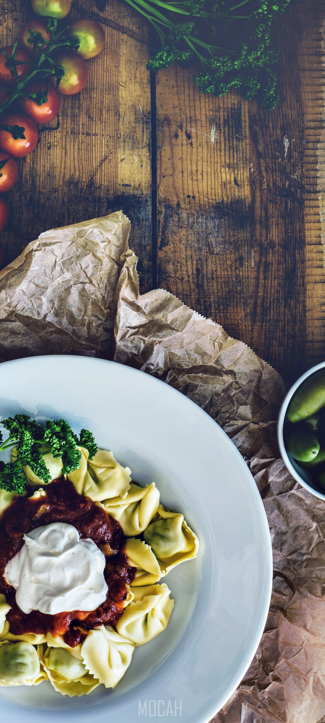 Tortelloni with tomato sauce and sour cream on a plate HD Phone Wallpaper