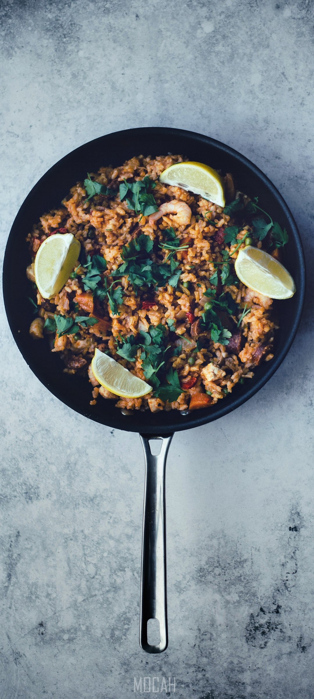 Paella in a pan with lime and cilantro HD Phone Wallpaper