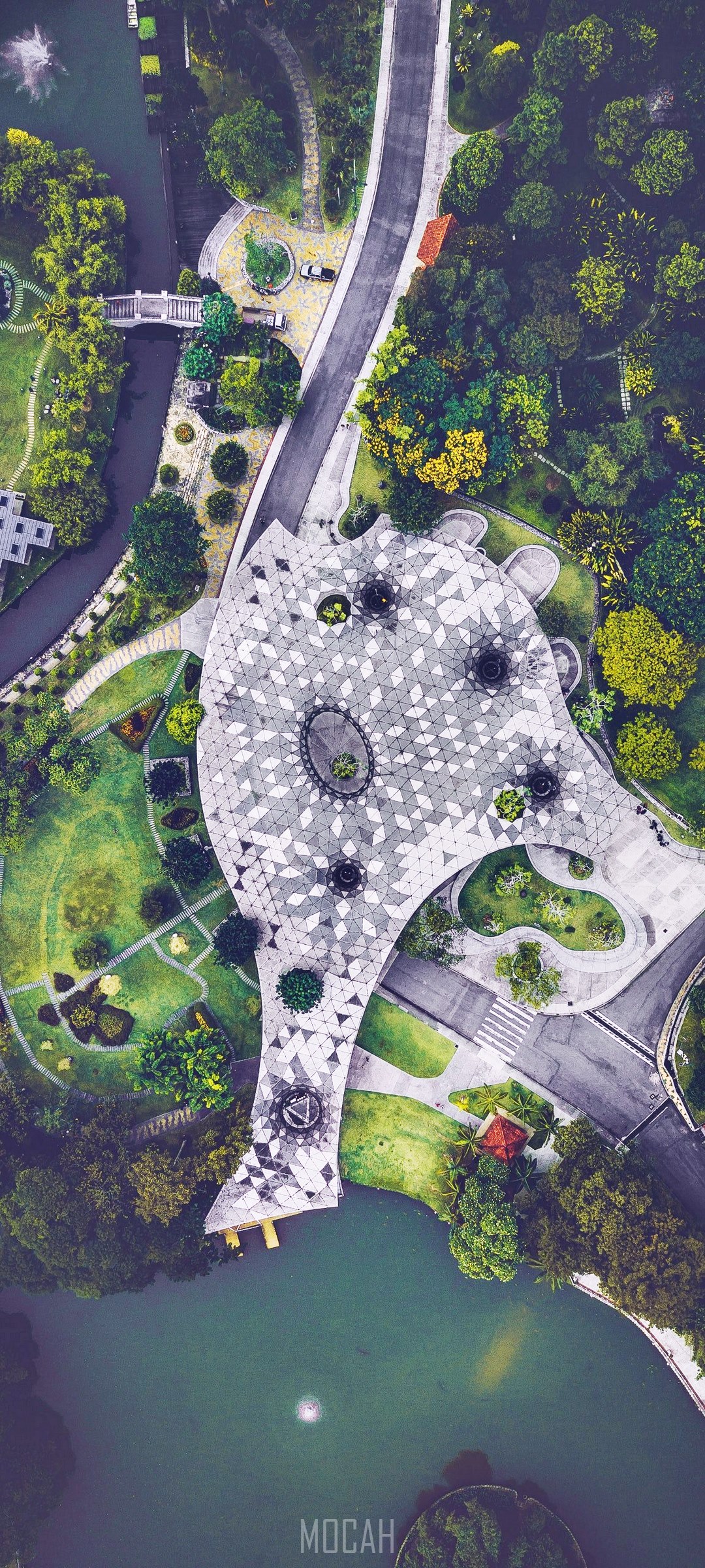 Aerial view of a lake and garden with a unique building HD Phone Wallpaper