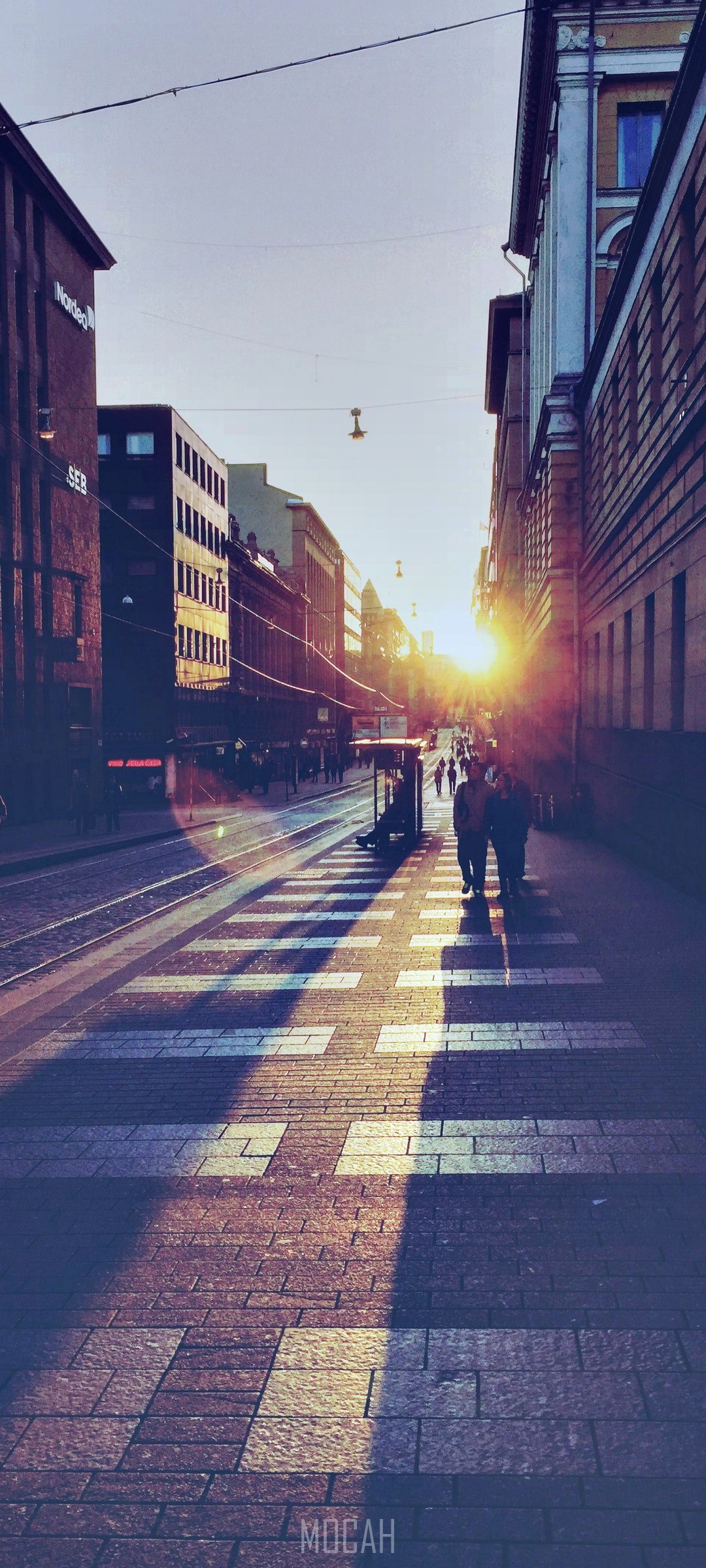 Sunset over a city street with pedestrians HD Phone Wallpaper