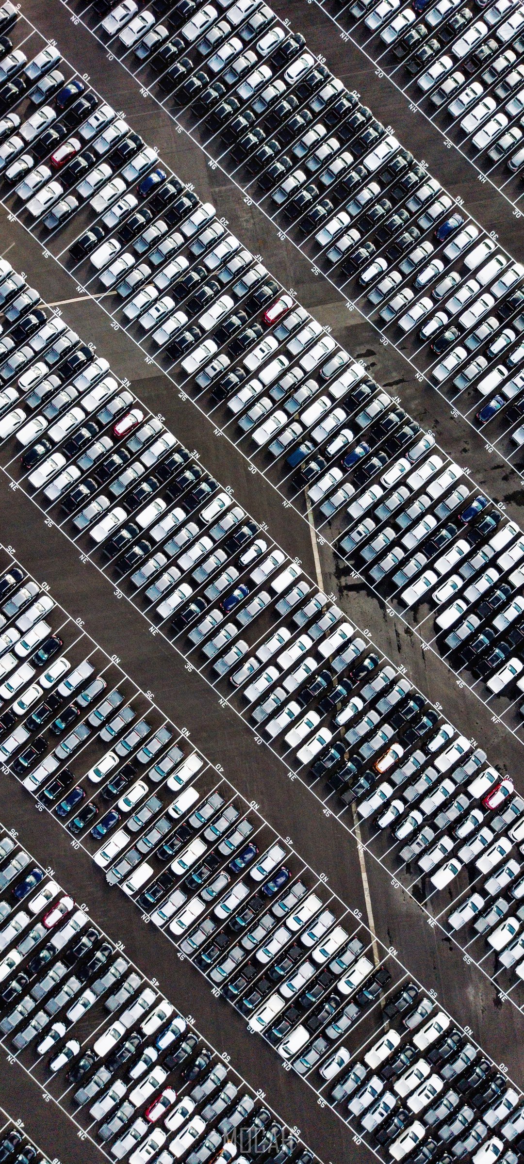 Aerial view of a large car parking lot with rows of cars HD Phone Wallpaper