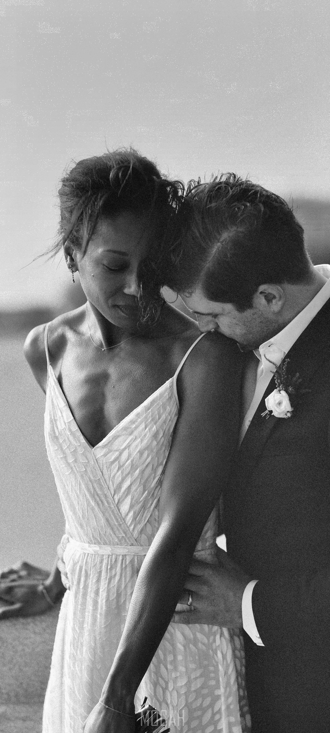 Bride and groom embracing by the water HD Phone Wallpaper