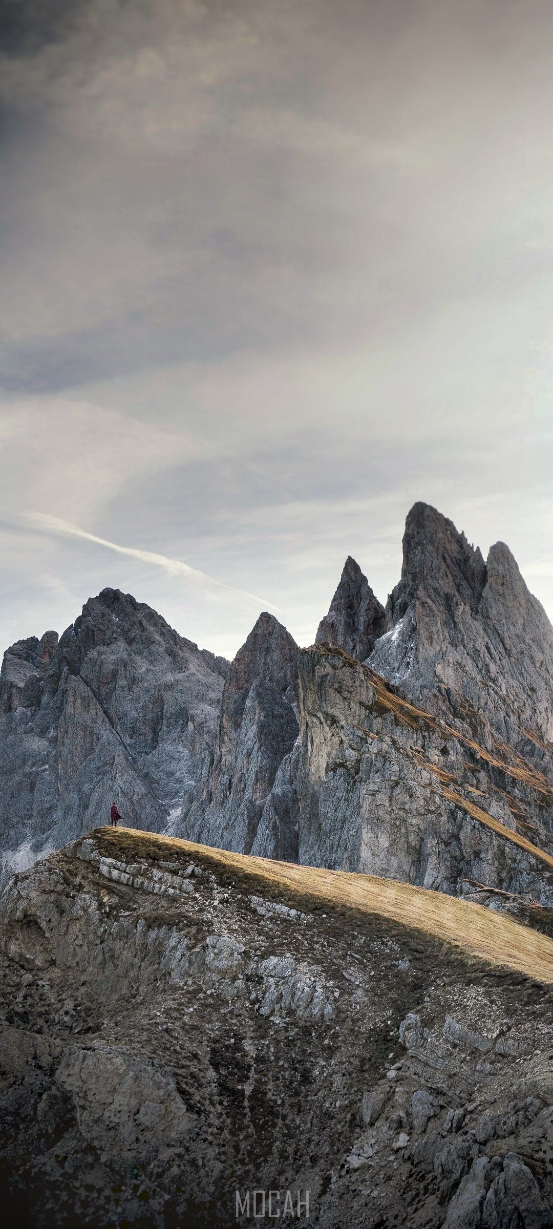 Person on mountain ridge overlooking jagged peaks HD Phone Wallpaper