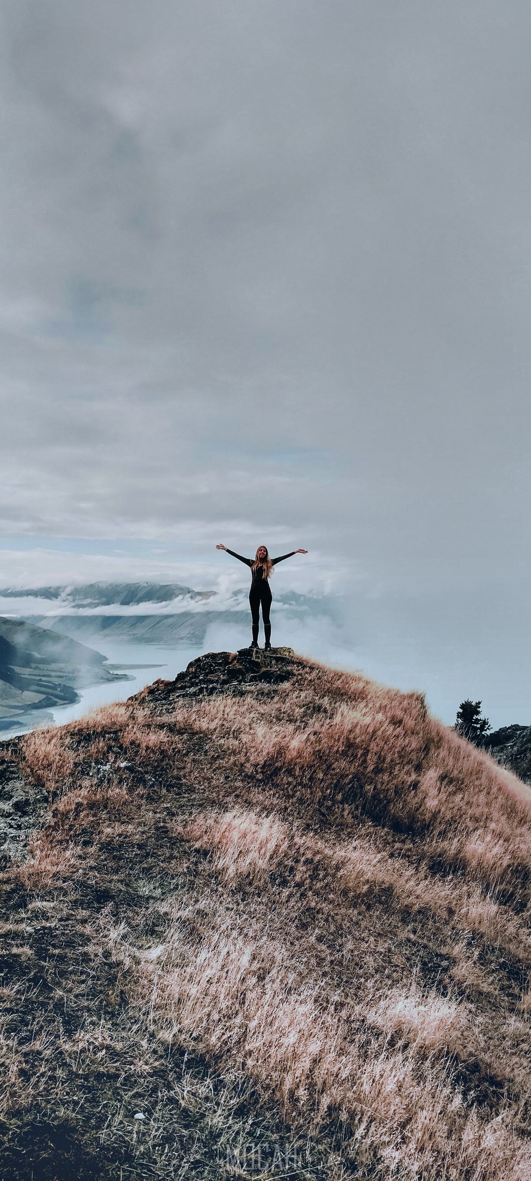 Woman on cliff overlooking a foggy landscape HD Phone Wallpaper