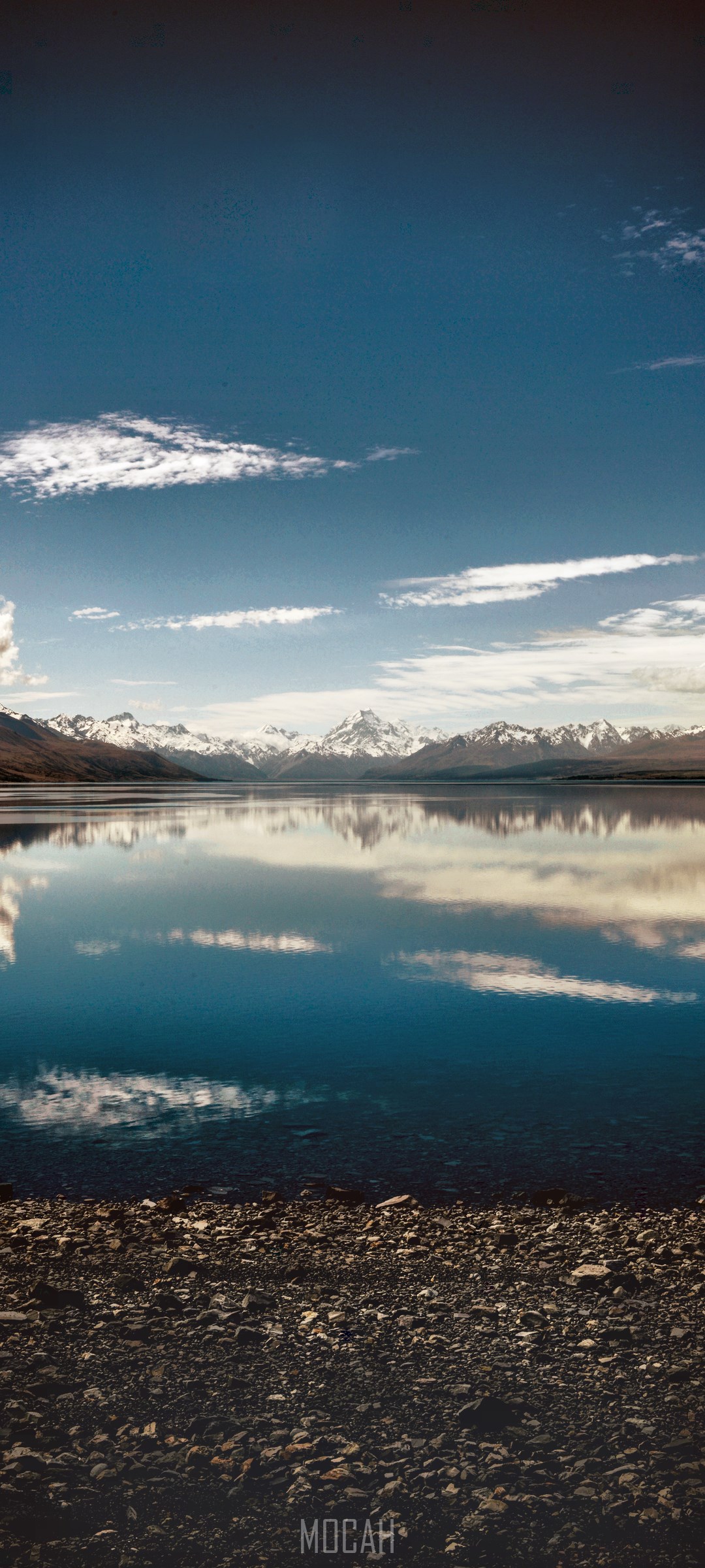 Snow-capped mountains reflected in a calm lake under a blue sky HD Phone Wallpaper