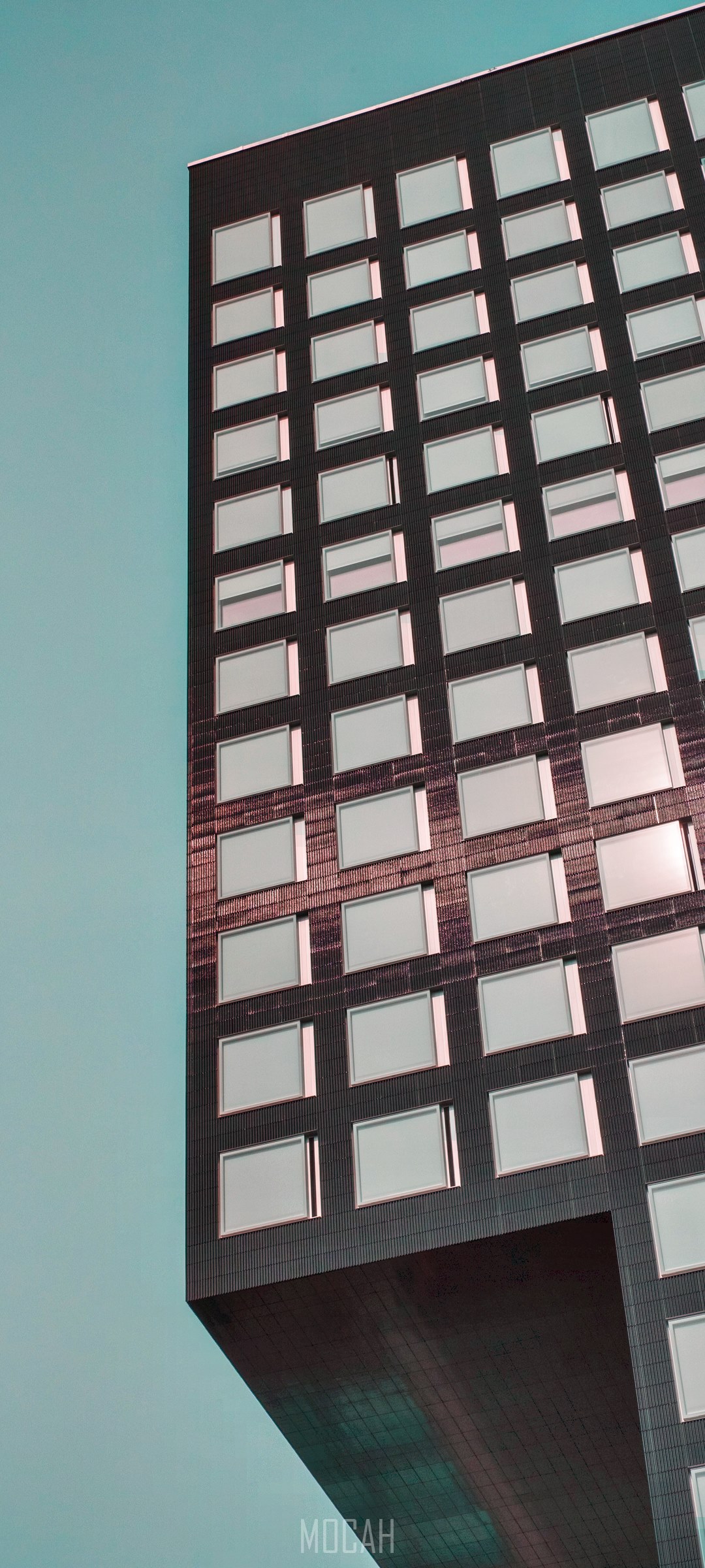 Modern skyscraper with many windows against a teal sky HD Phone Wallpaper