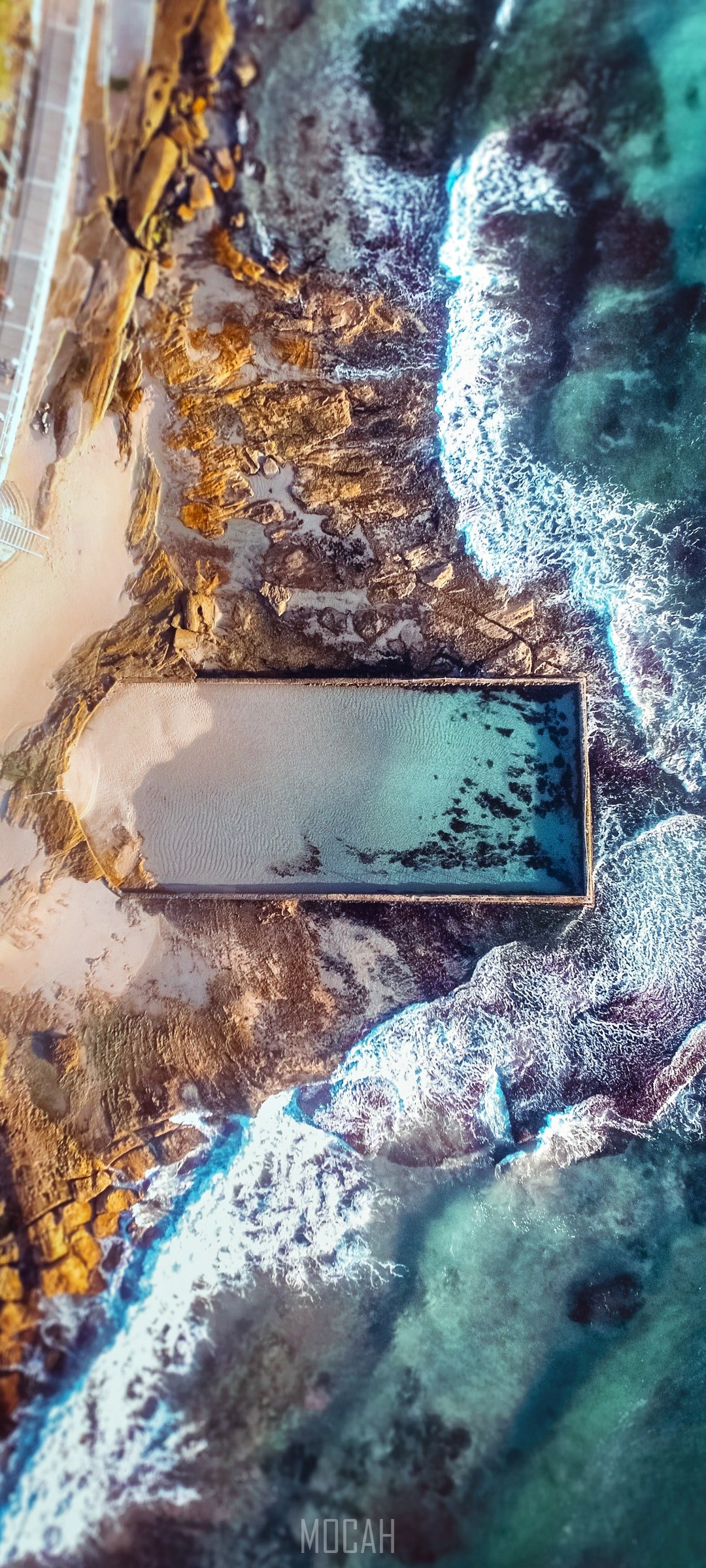 Aerial view of a rectangular ocean pool next to rocky coastline HD Phone Wallpaper