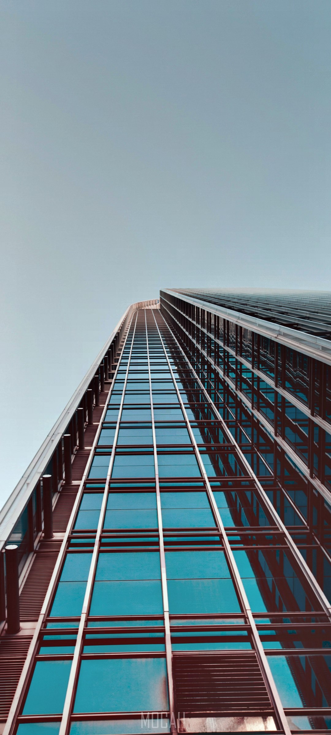 Modern skyscraper with glass facade against clear sky HD Phone Wallpaper
