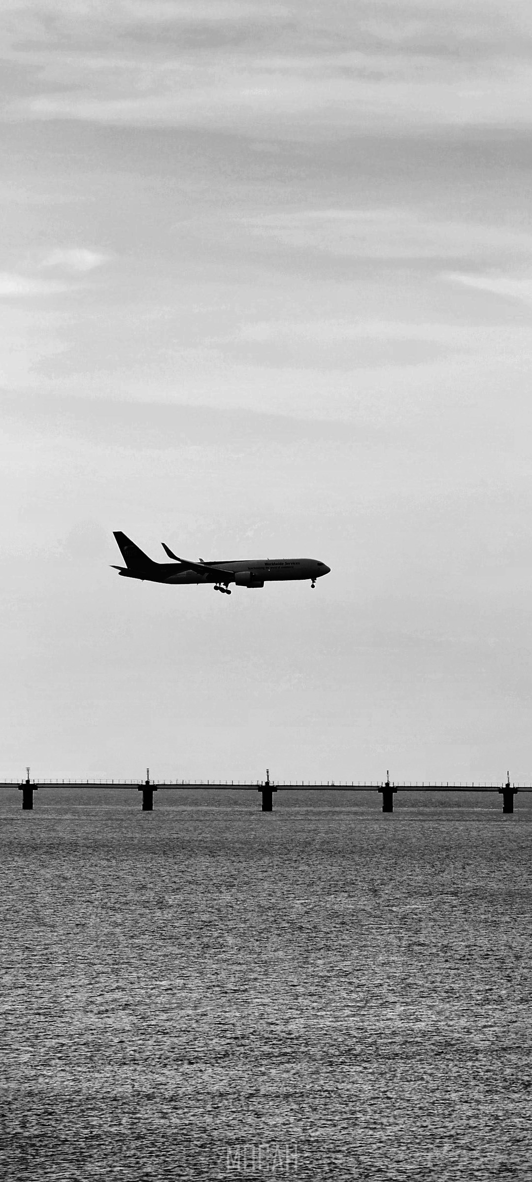 Airplane landing over water near bridge HD Phone Wallpaper