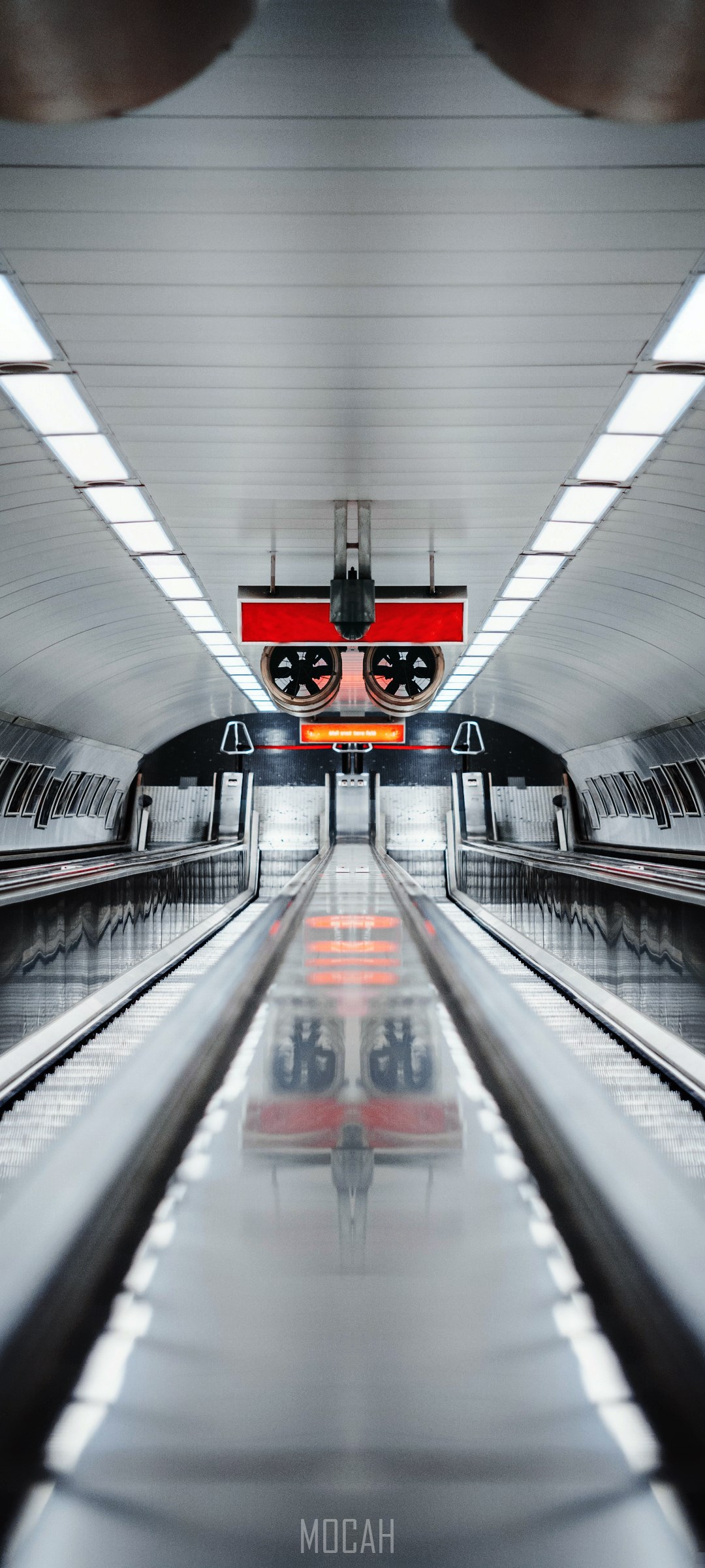 Symmetrical Subway Station with Escalators and Red Signs HD Phone Wallpaper