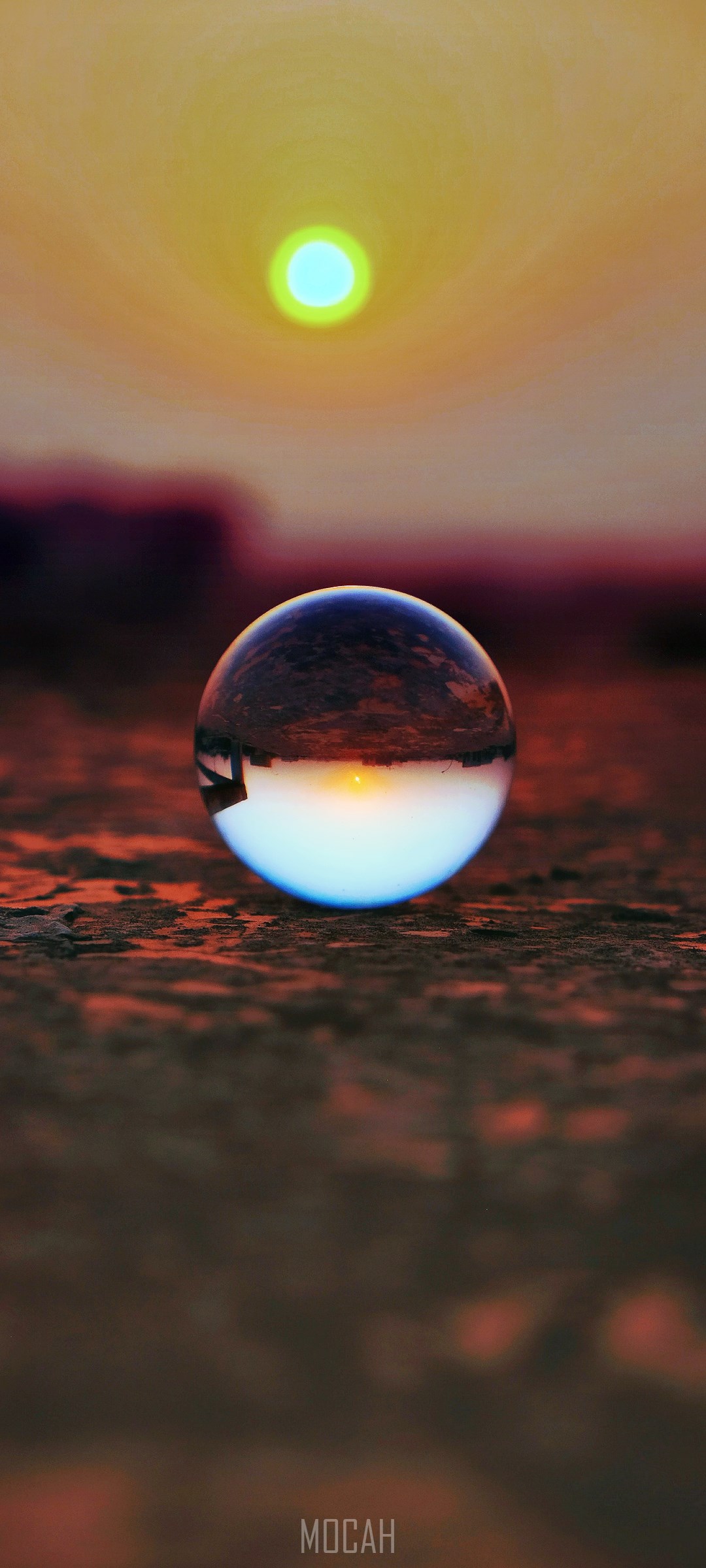 Sunset reflection in a glass ball on the ground HD Phone Wallpaper