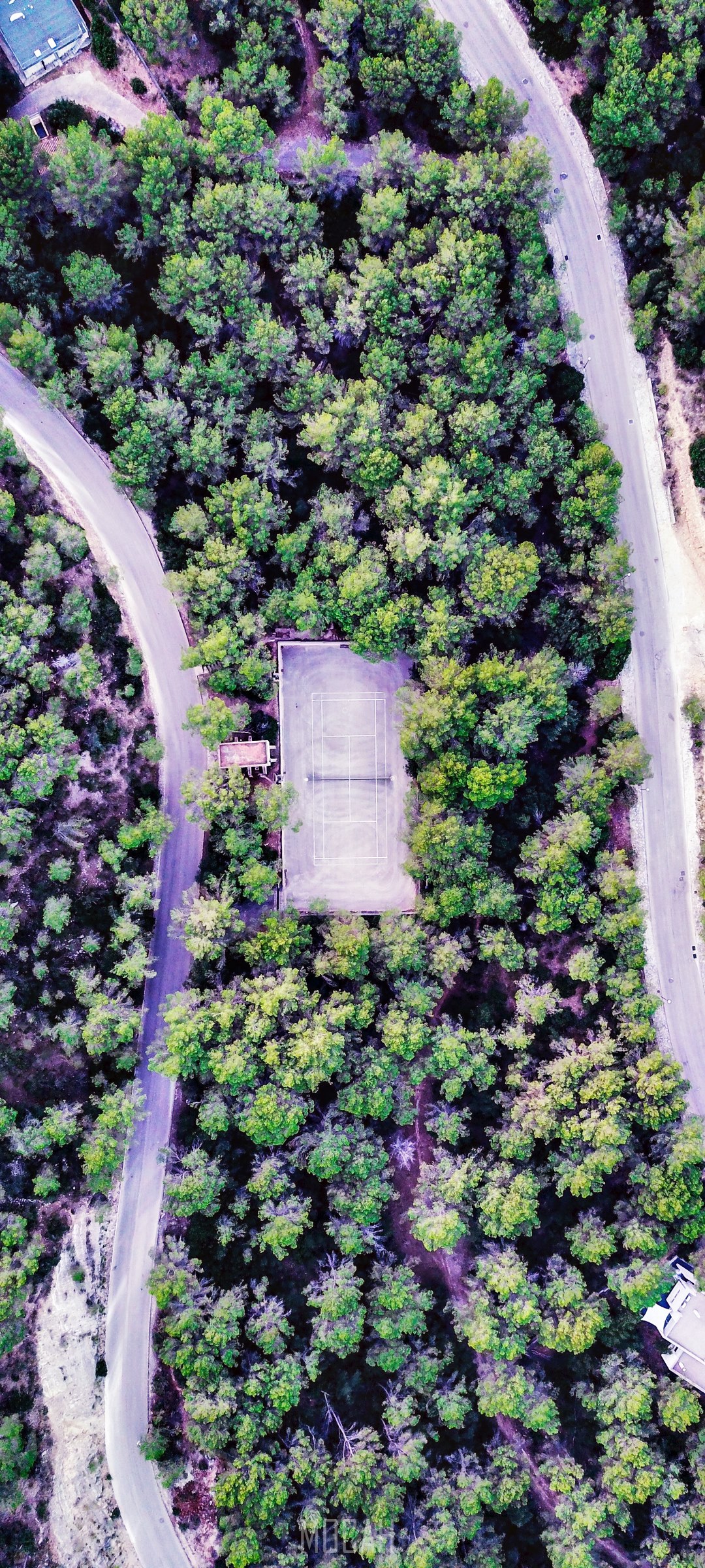 Tennis court surrounded by forest and roads HD Phone Wallpaper