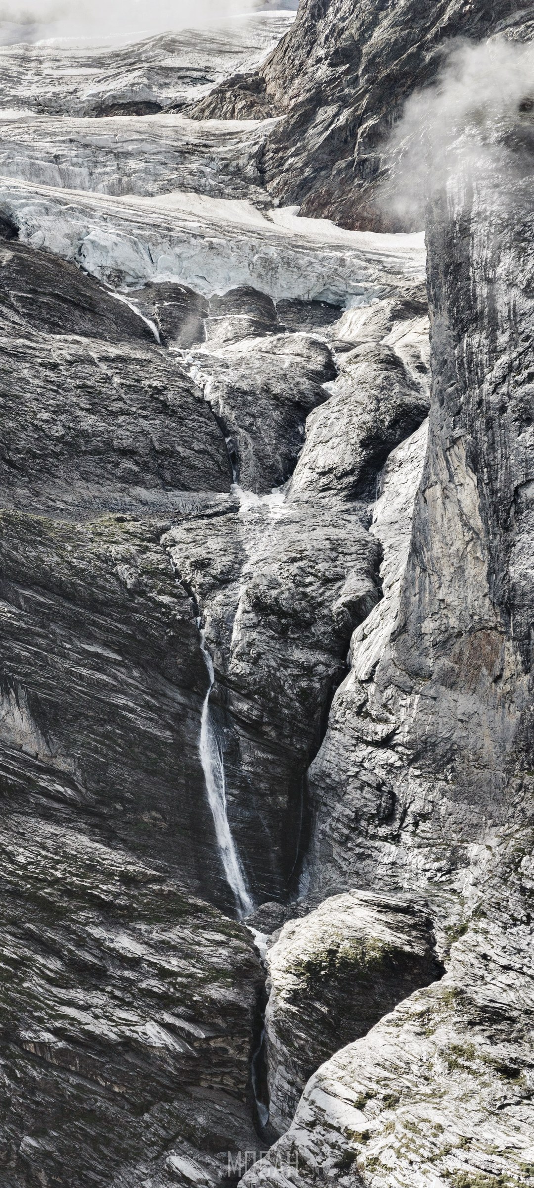 Waterfall cascading down a rocky cliff face HD Phone Wallpaper