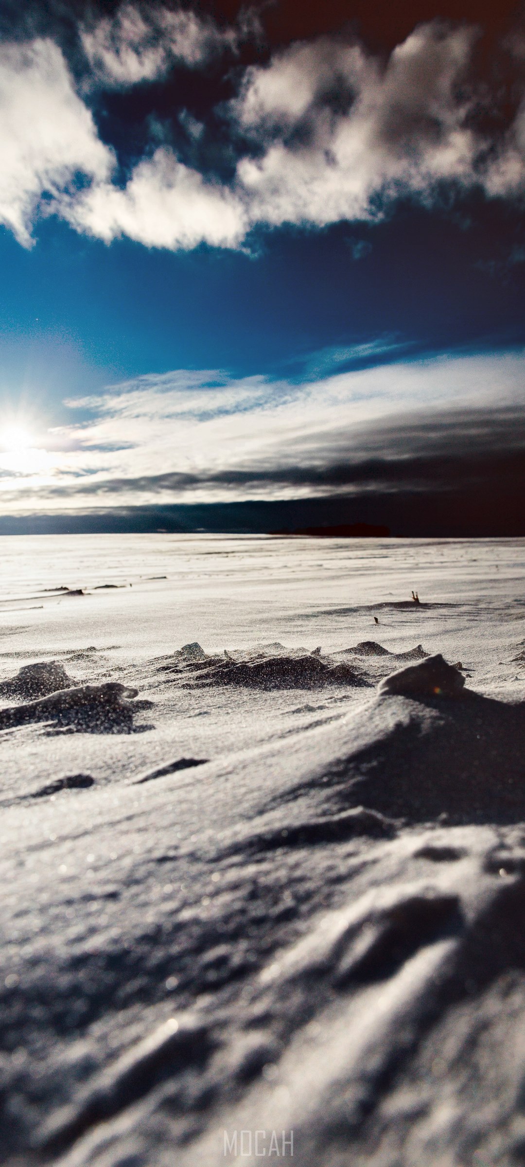 Snowy landscape under a cloudy blue sky HD Phone Wallpaper