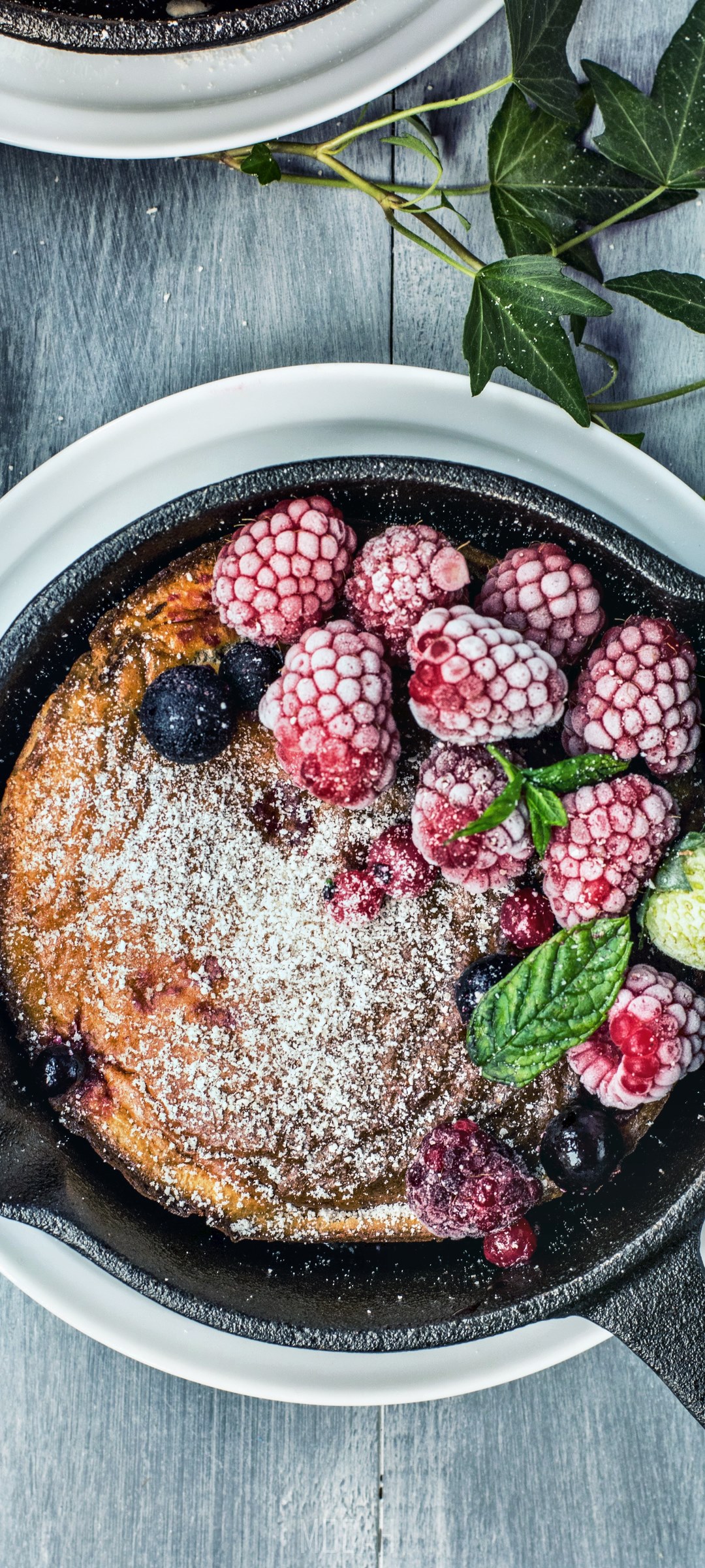 Dutch baby pancake with berries in cast iron skillet HD Phone Wallpaper
