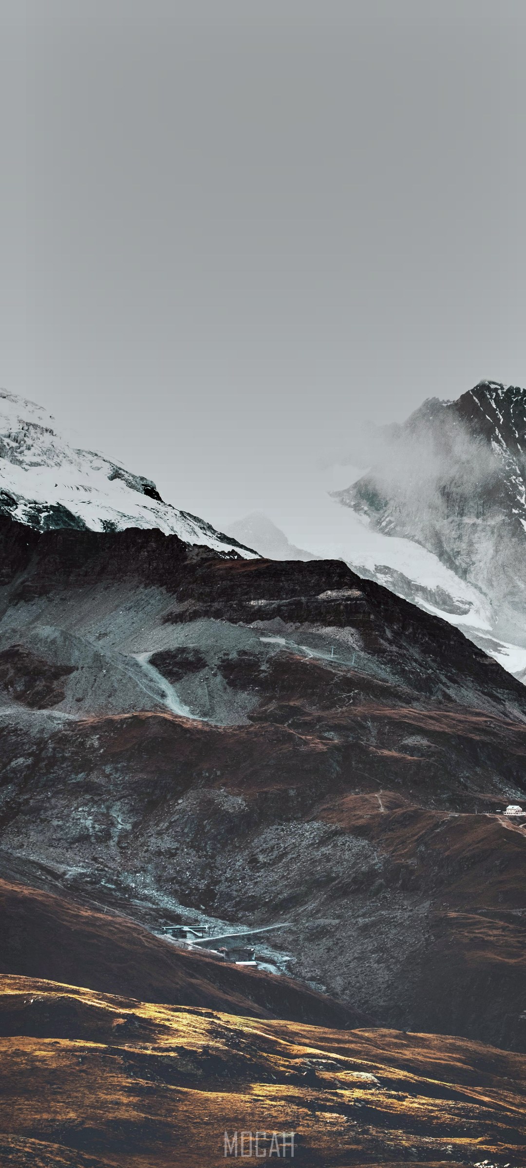Snowy mountain peaks with clouds and a small village HD Phone Wallpaper