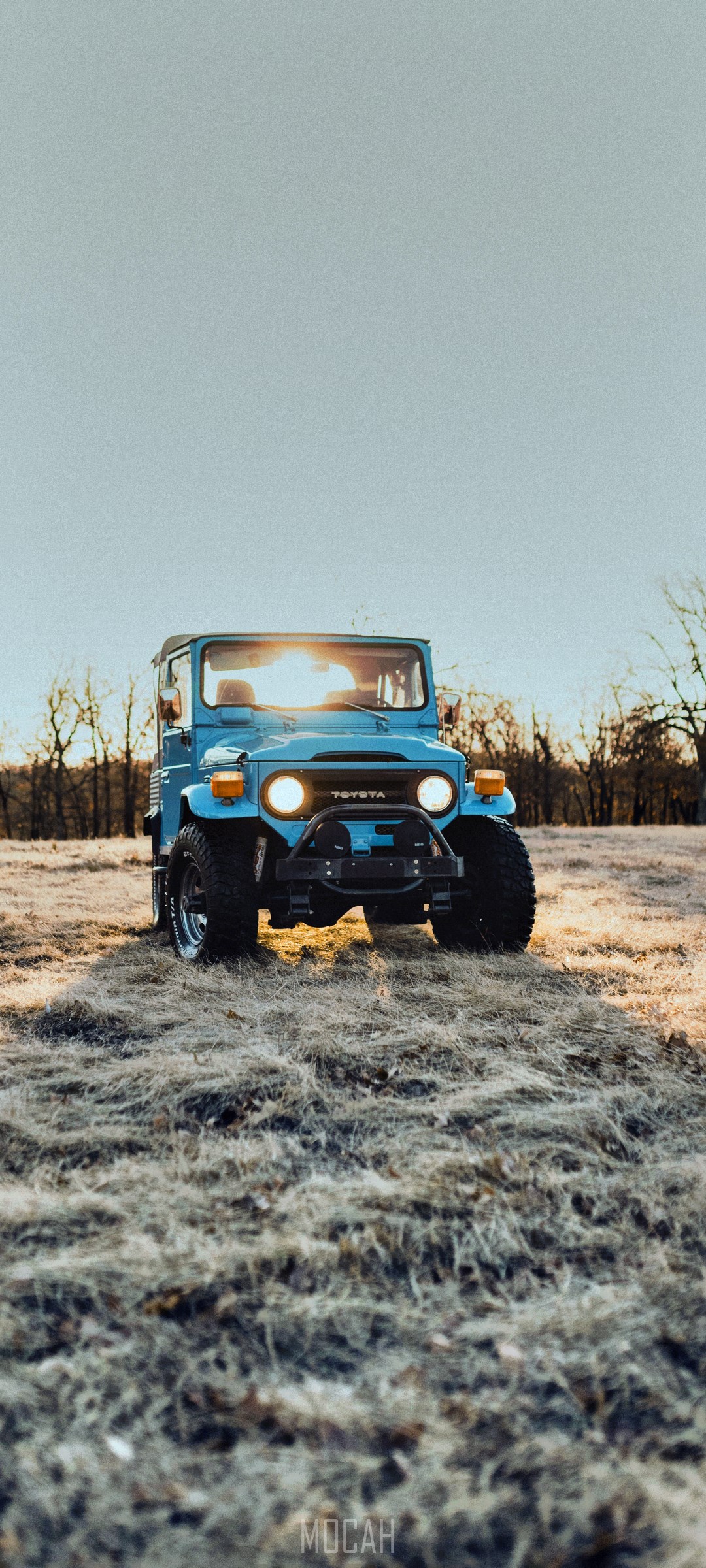 Blue Toyota Land Cruiser FJ40 off-roading in field HD Phone Wallpaper