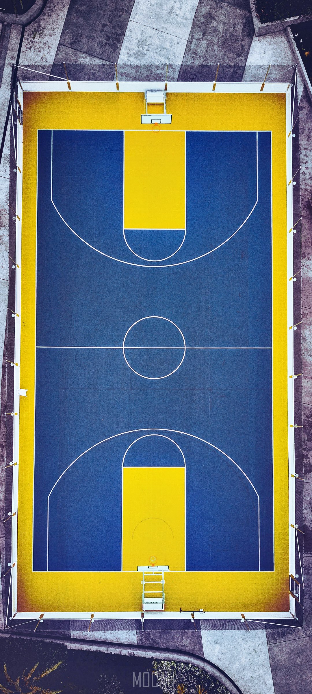 Aerial view of a blue and yellow basketball court HD Phone Wallpaper