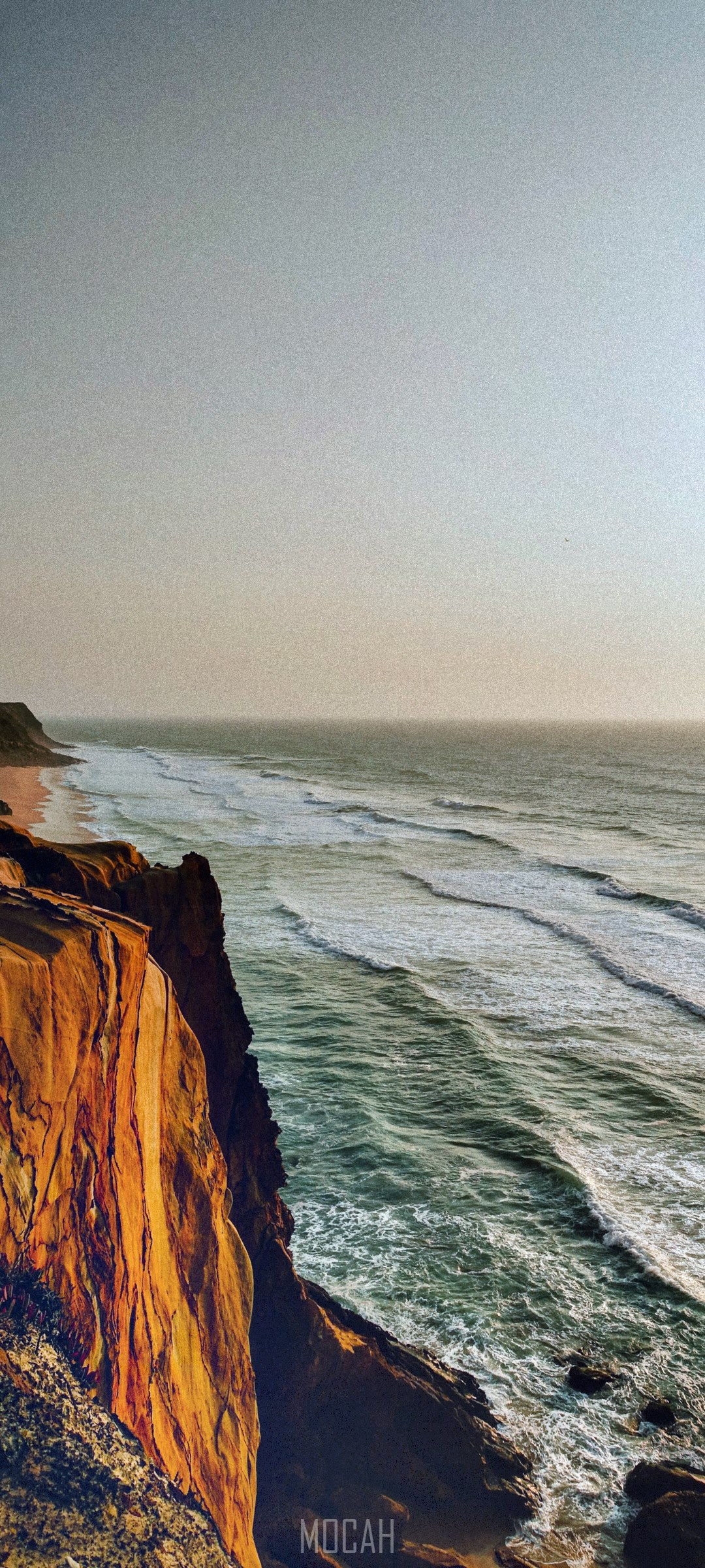 Golden cliff overlooking the ocean with waves HD Phone Wallpaper