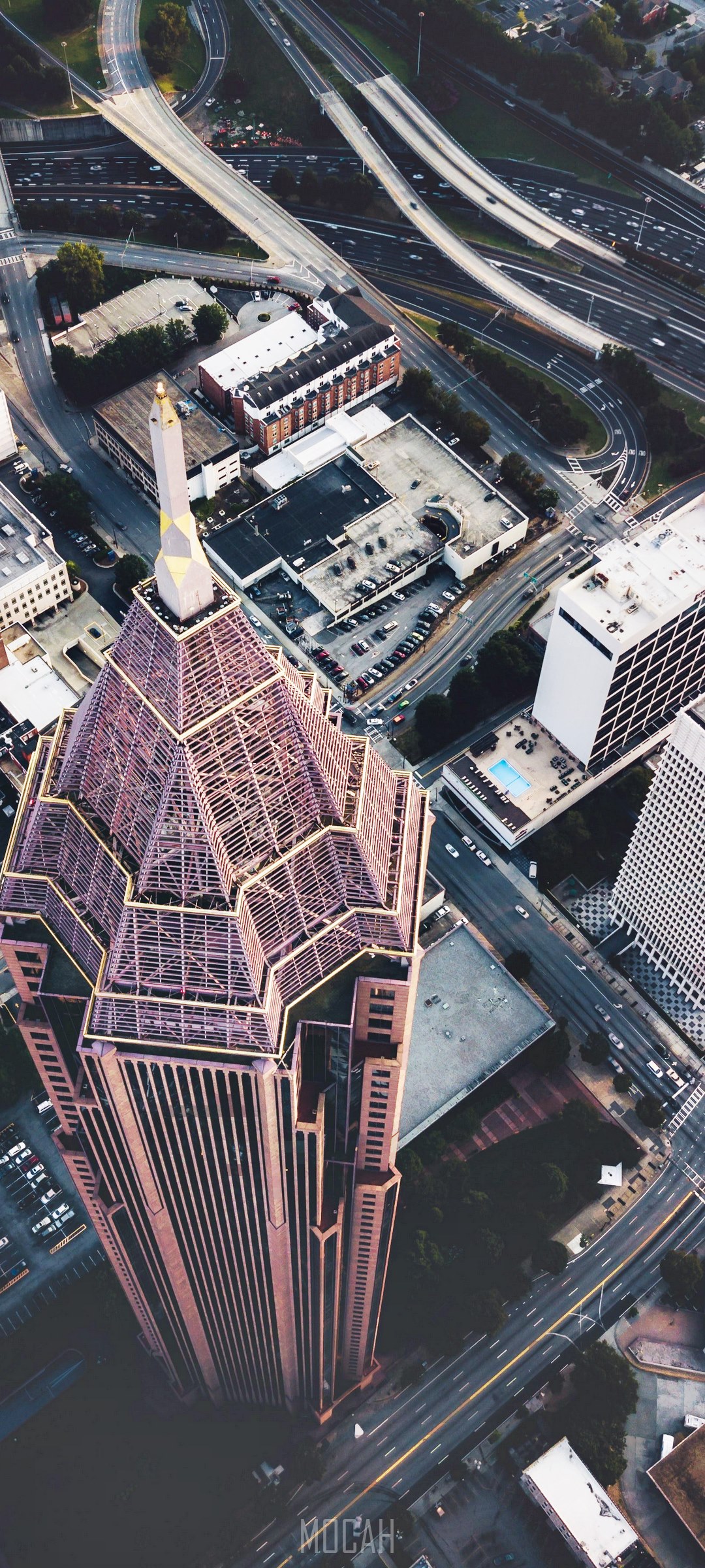 Aerial view of a skyscraper and highway interchange HD Phone Wallpaper