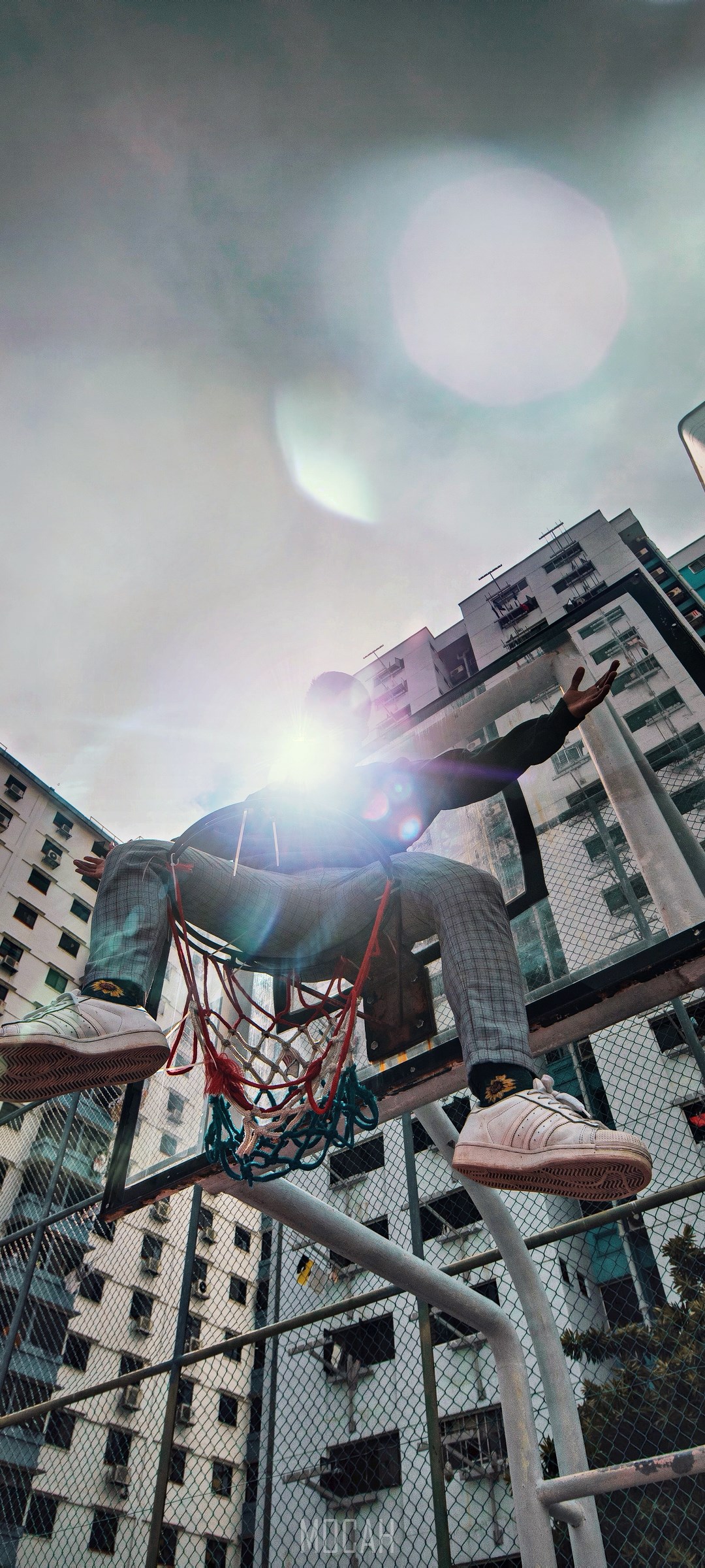Person on basketball hoop with buildings HD Phone Wallpaper