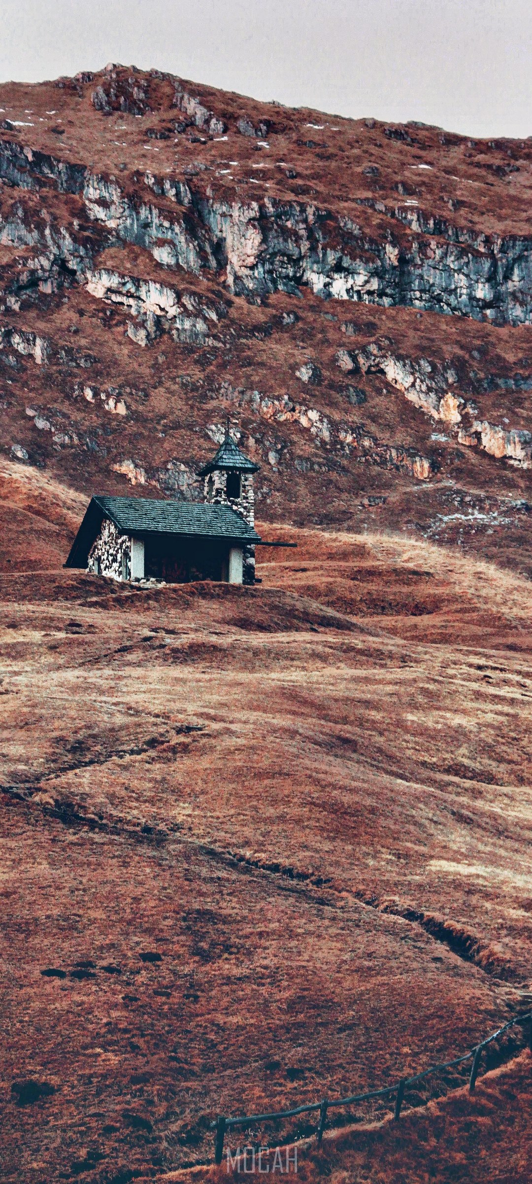 Small stone church on a grassy mountain slope HD Phone Wallpaper