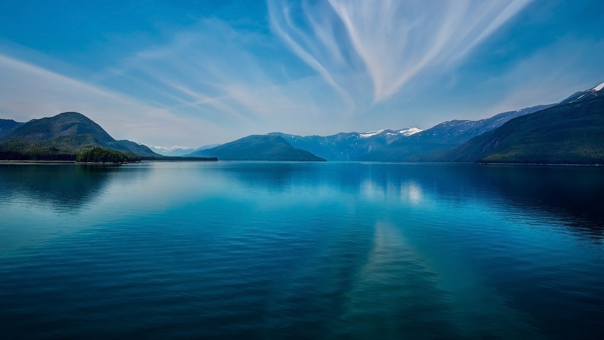 Calm lake reflecting mountains and sky HD Wallpaper