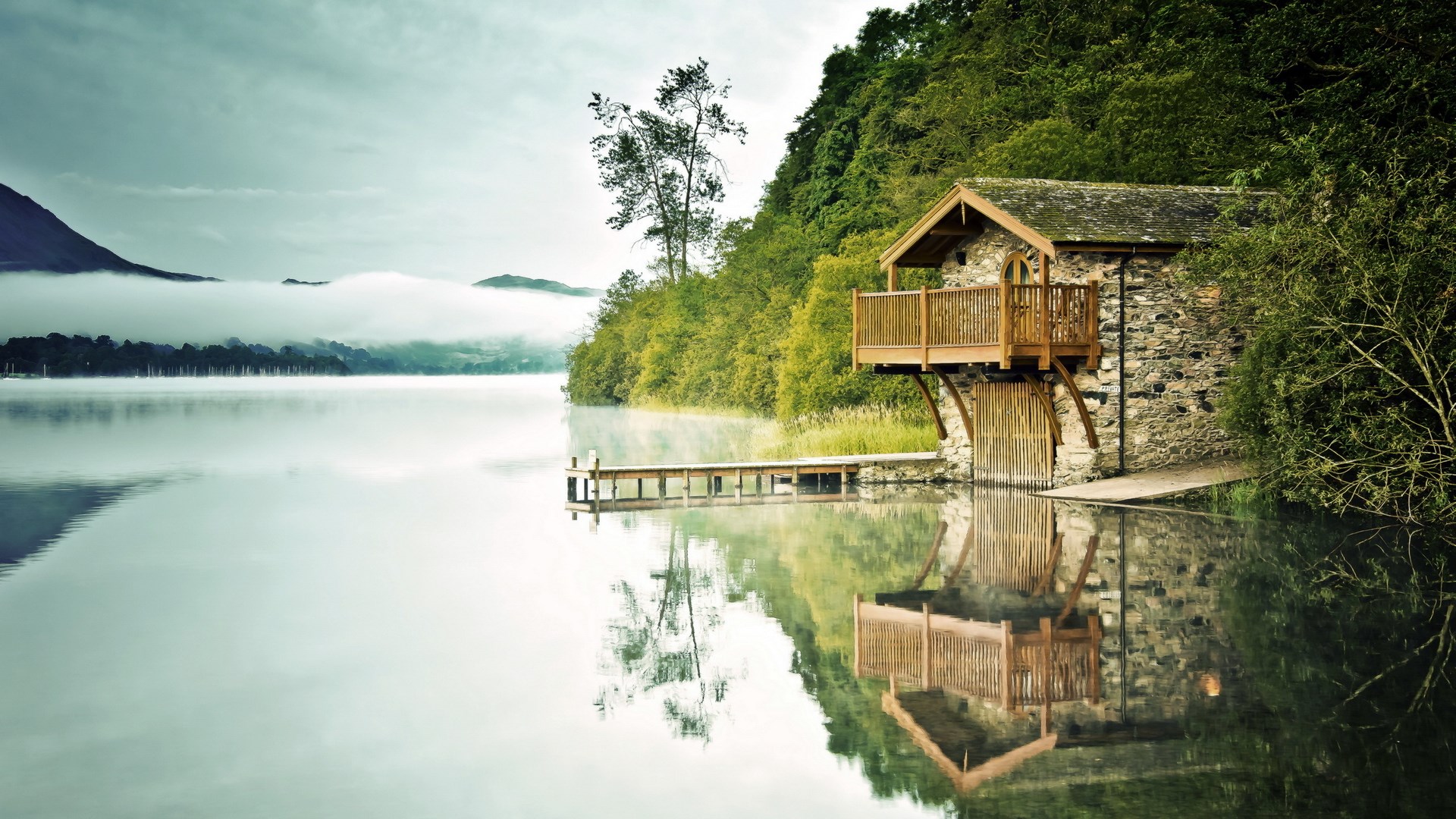 Stone boathouse on a misty lake with wooden dock HD Wallpaper