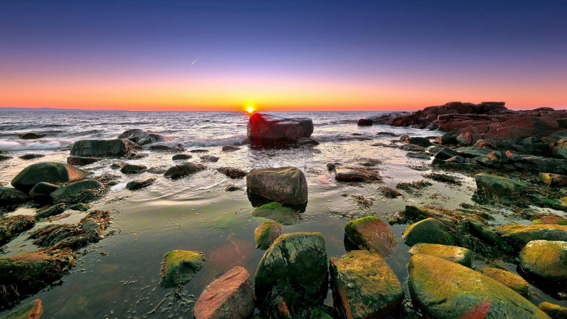 Sunset over rocky coastline with ocean waves HD Wallpaper