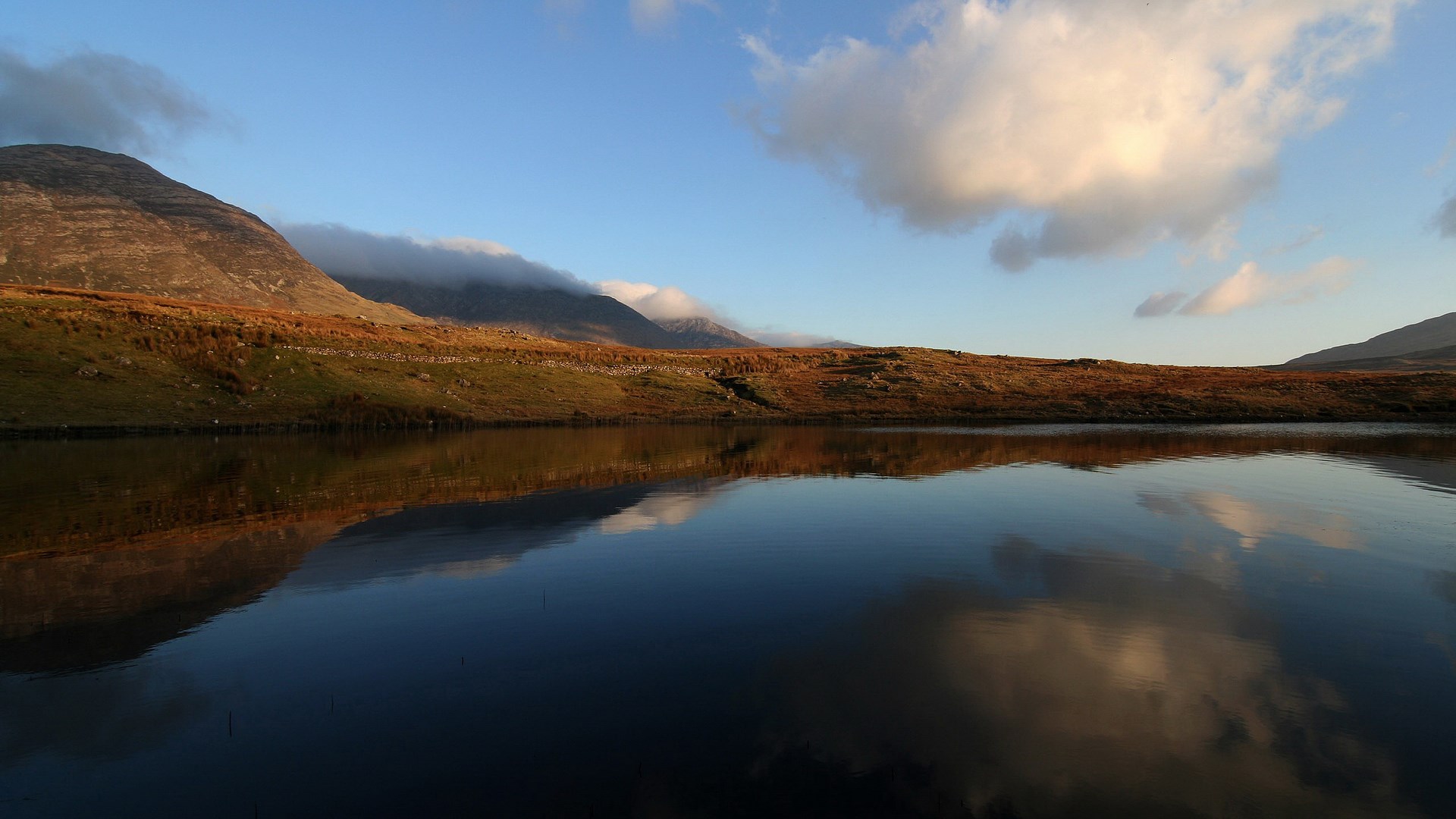 Mountain landscape reflected in a calm lake at sunset HD Wallpaper