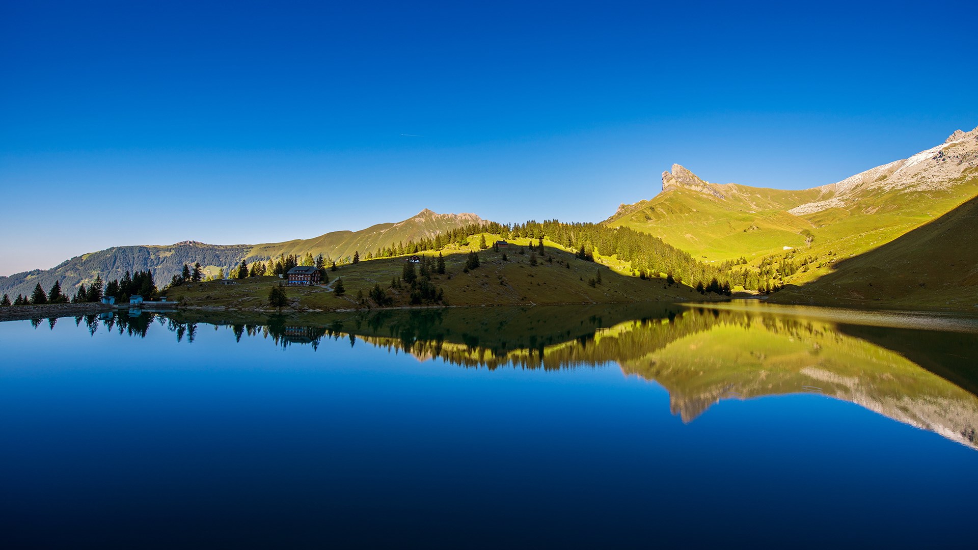 Mountain lake with reflections and buildings HD Wallpaper