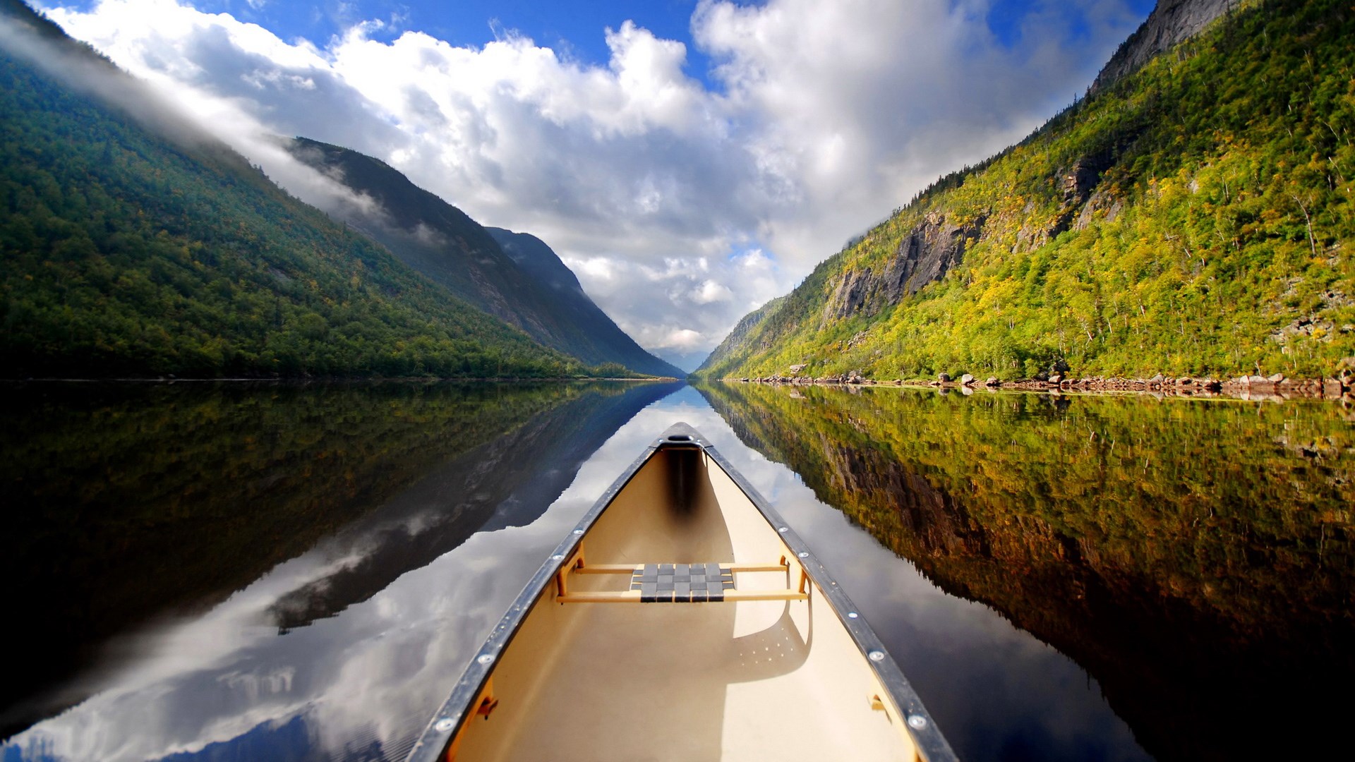 Canoe on a calm lake between mountains HD Wallpaper