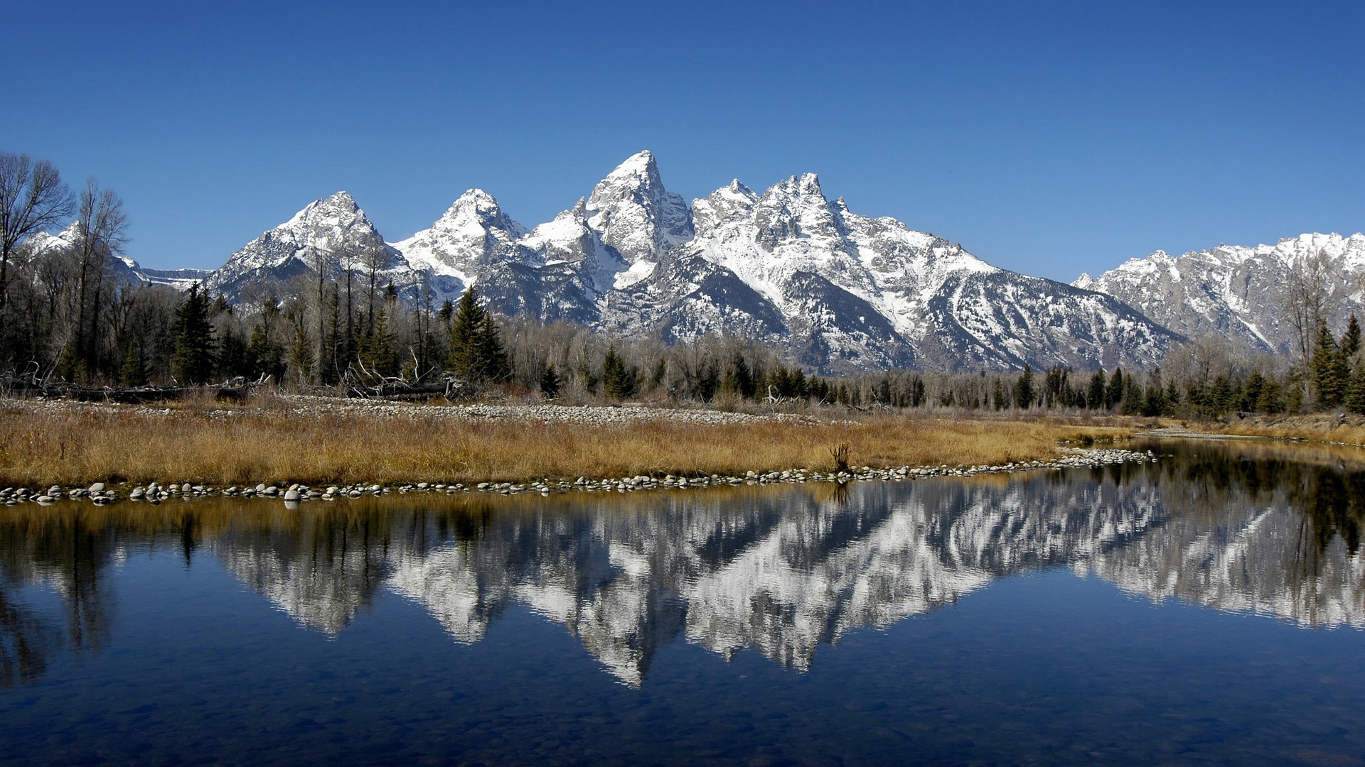 Snow-capped mountains reflected in a calm river HD Wallpaper