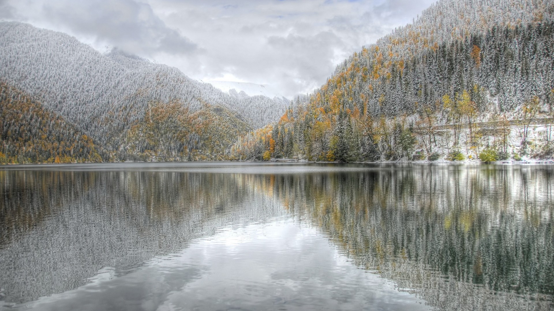 Snow-dusted mountains reflected in a calm lake HD Wallpaper