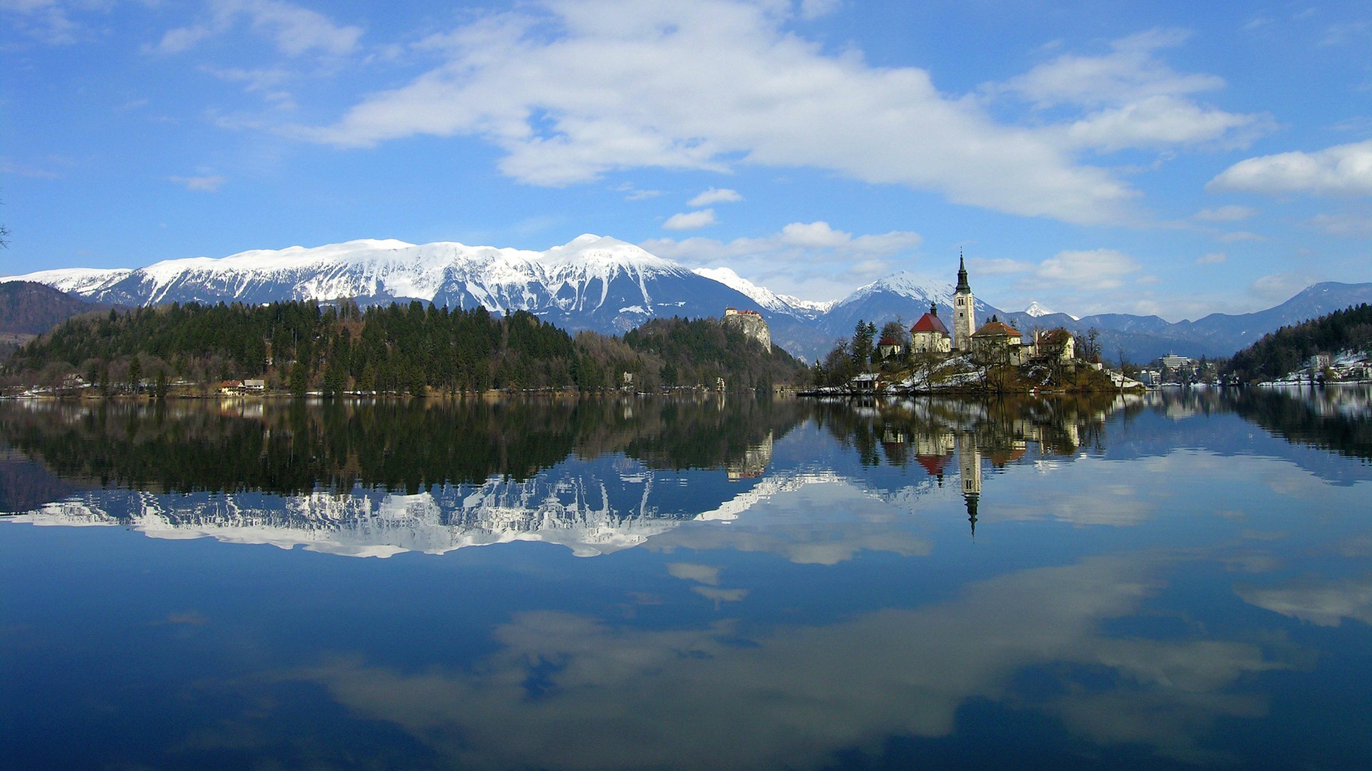 Church on an island in a lake with snowy mountains HD Wallpaper