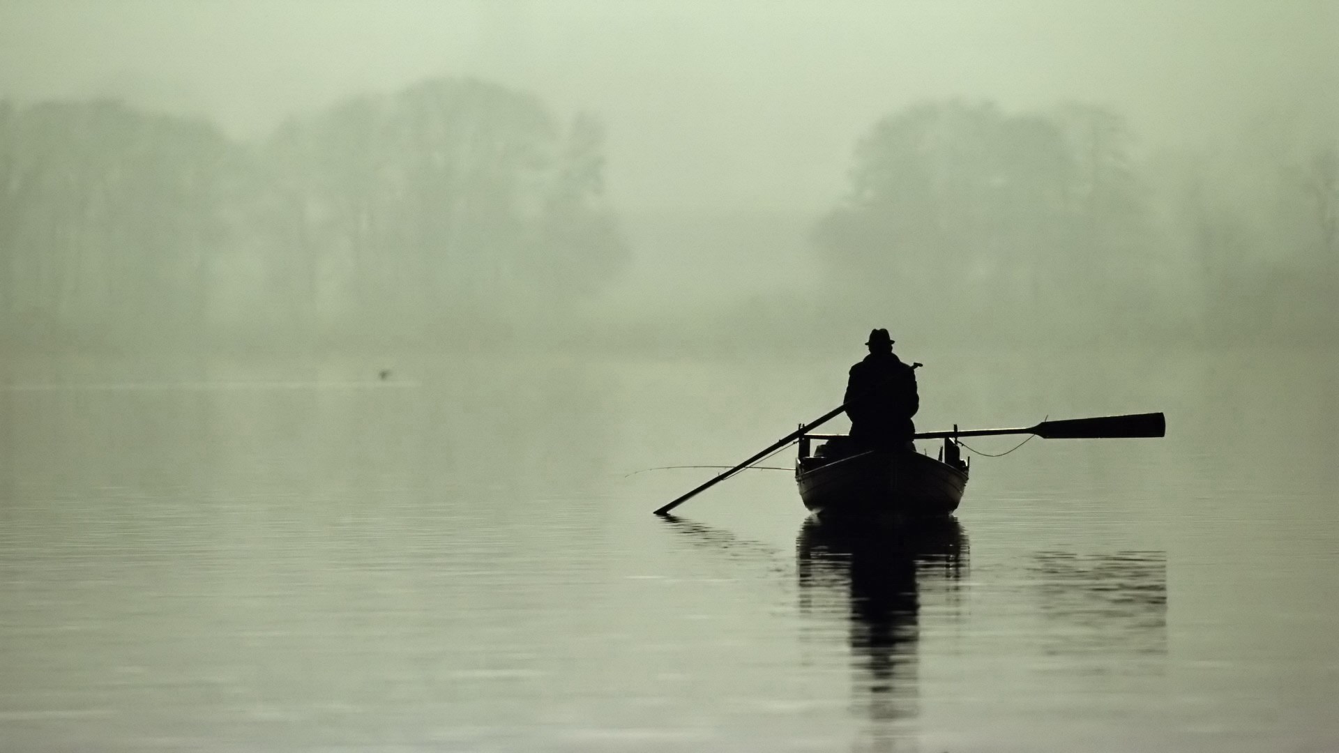 Man rowing a boat on a foggy lake HD Wallpaper