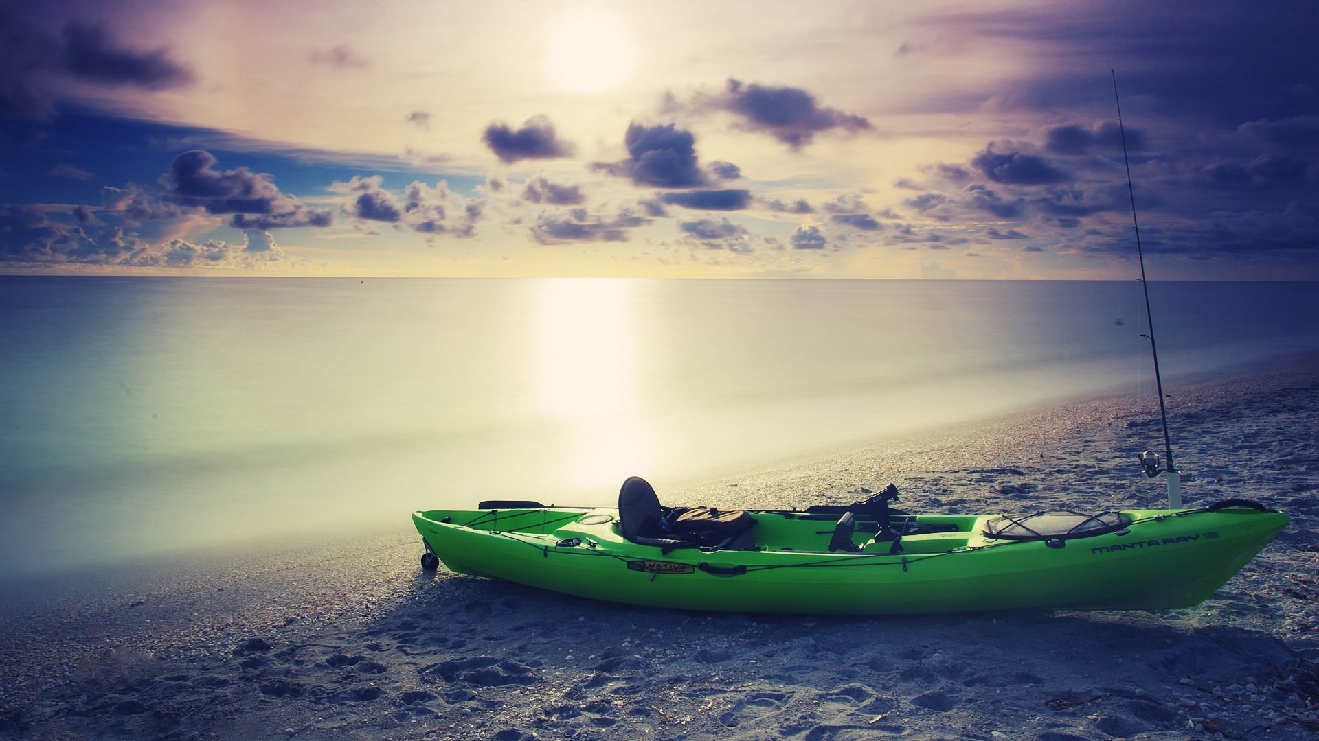 Kayak and fishing rod on a beach at sunset HD Wallpaper
