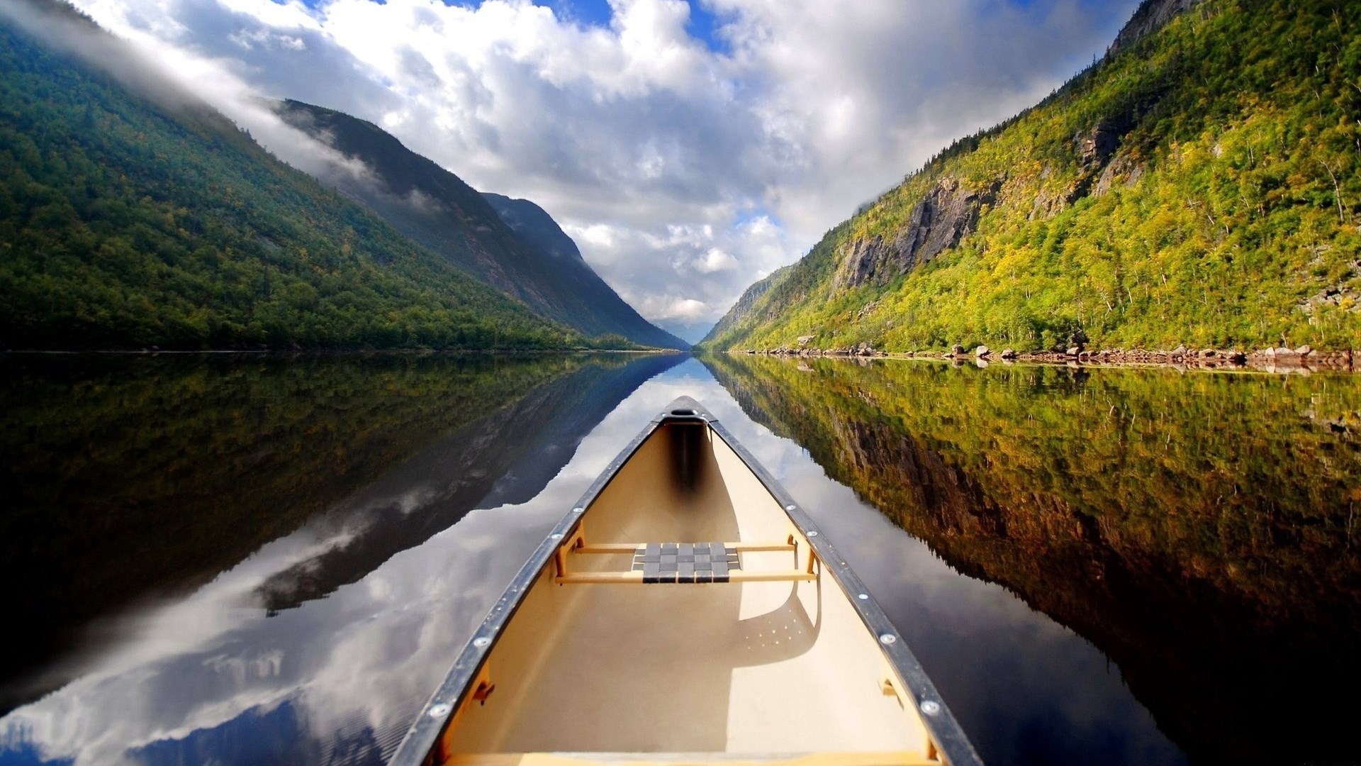 Canoe on a calm lake between mountains HD Wallpaper