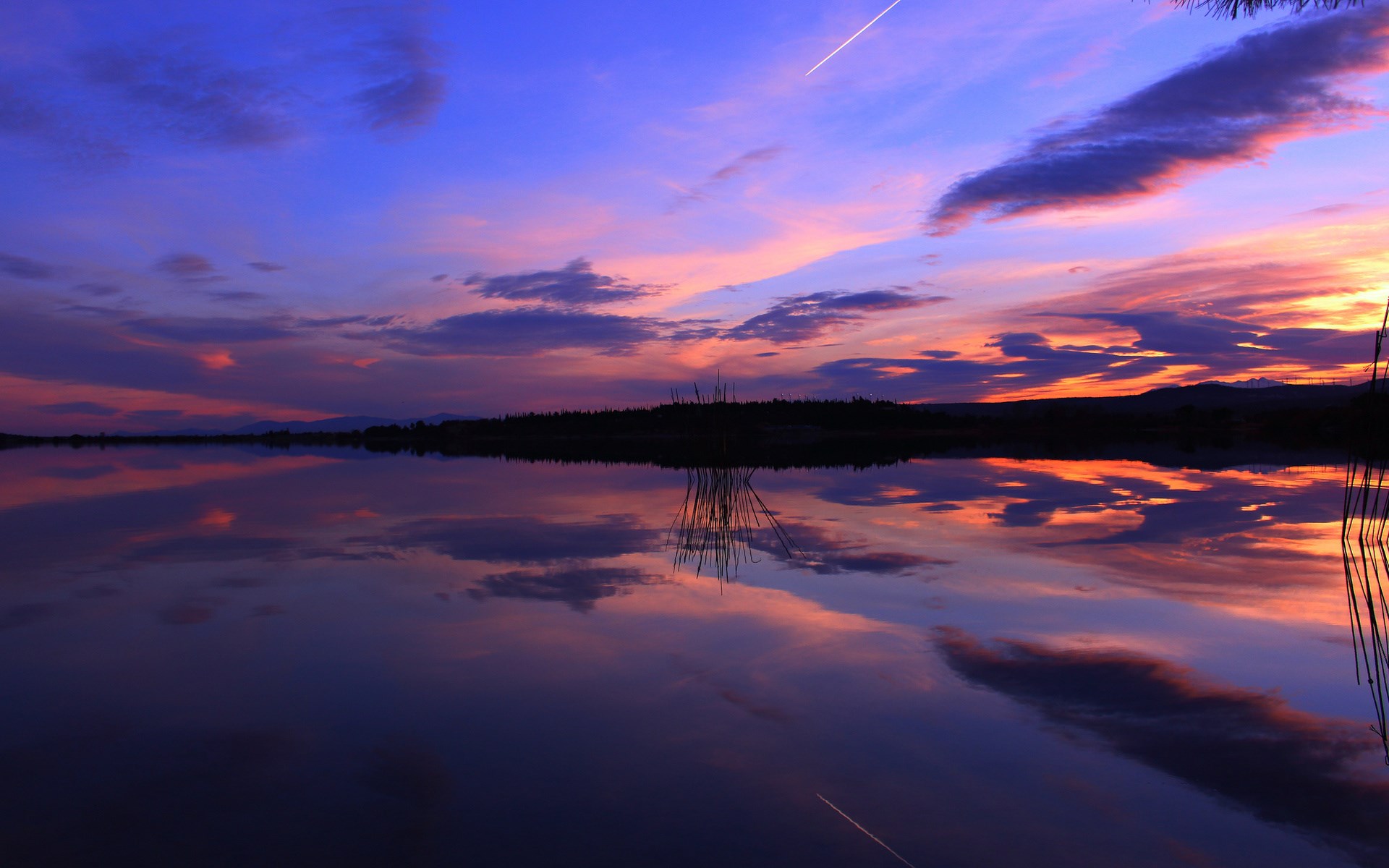 Sunset over a calm lake with colorful clouds and reflections HD Wallpaper