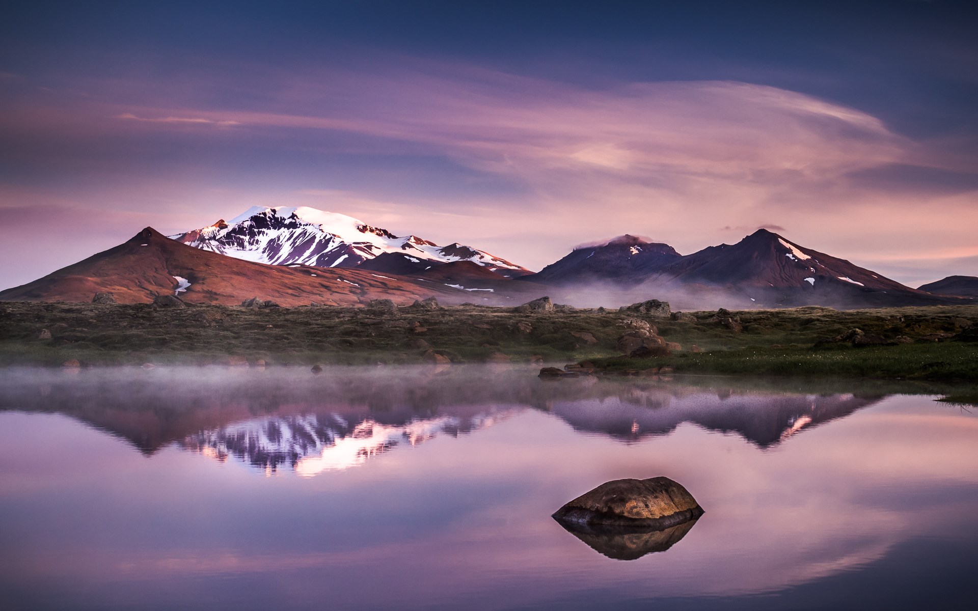 Misty mountains reflected in a calm lake at sunrise HD Wallpaper
