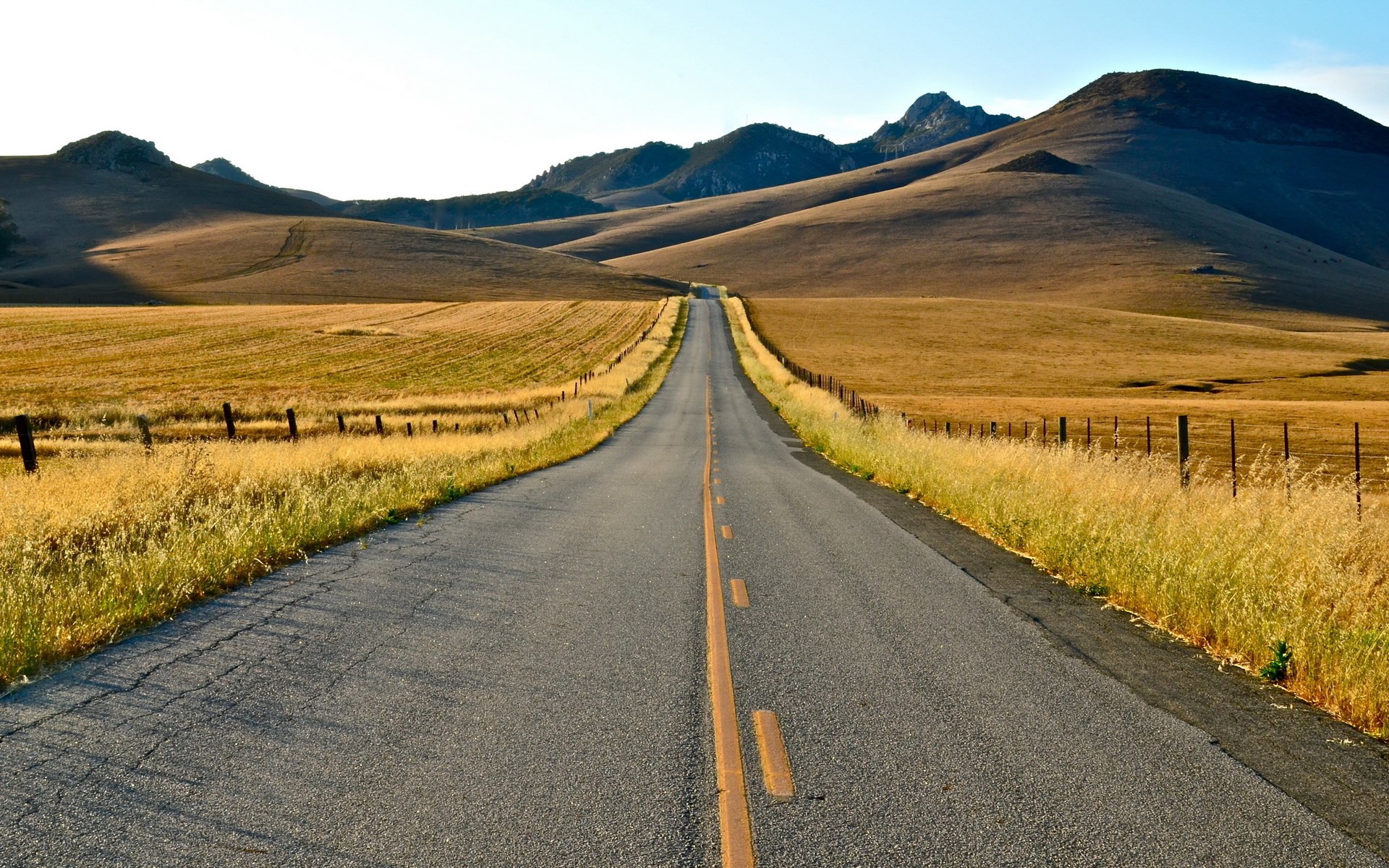 Empty road through rolling hills and dry grass HD Wallpaper