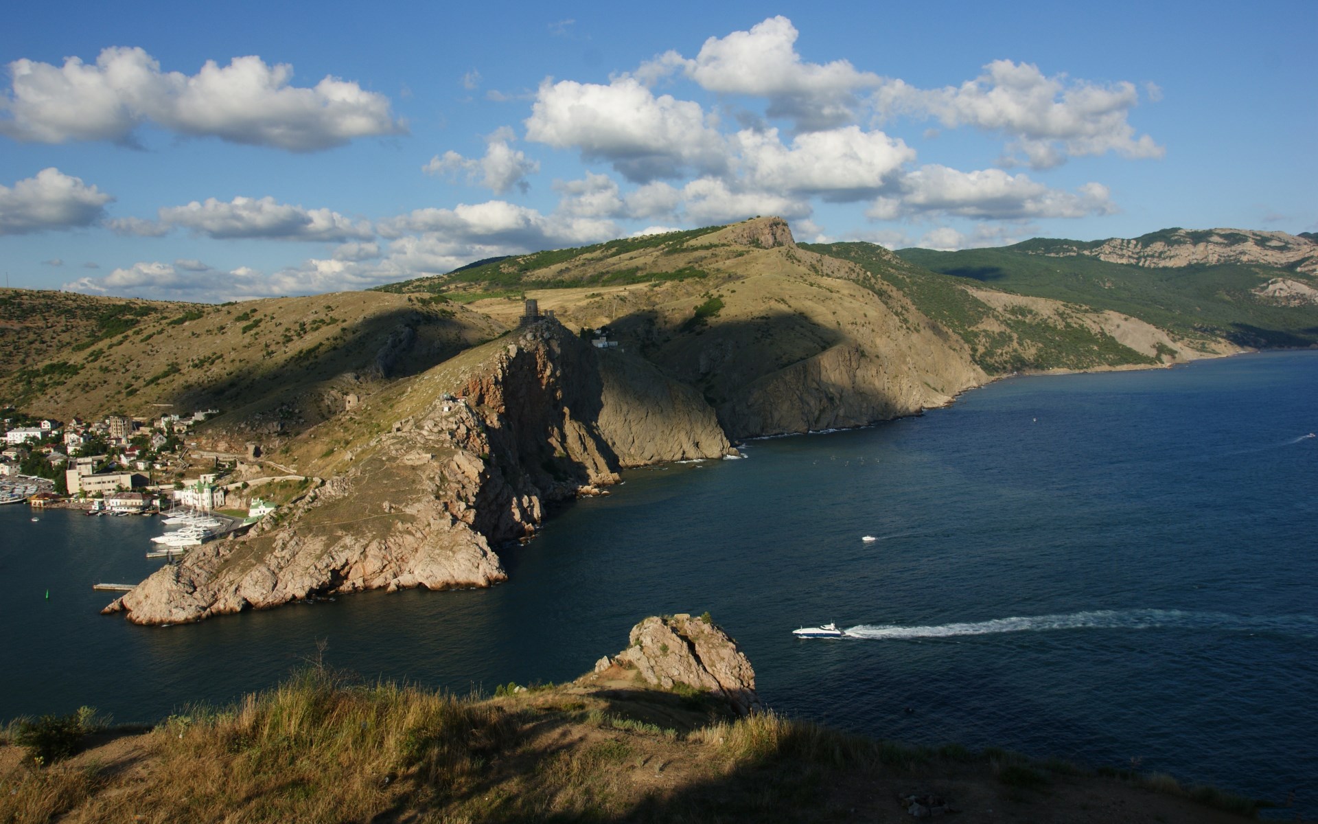 Coastal town with rocky cliffs and blue sea HD Wallpaper