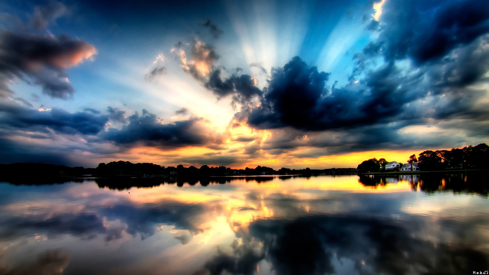 Sunset over a lake with dramatic clouds and reflections HD Wallpaper